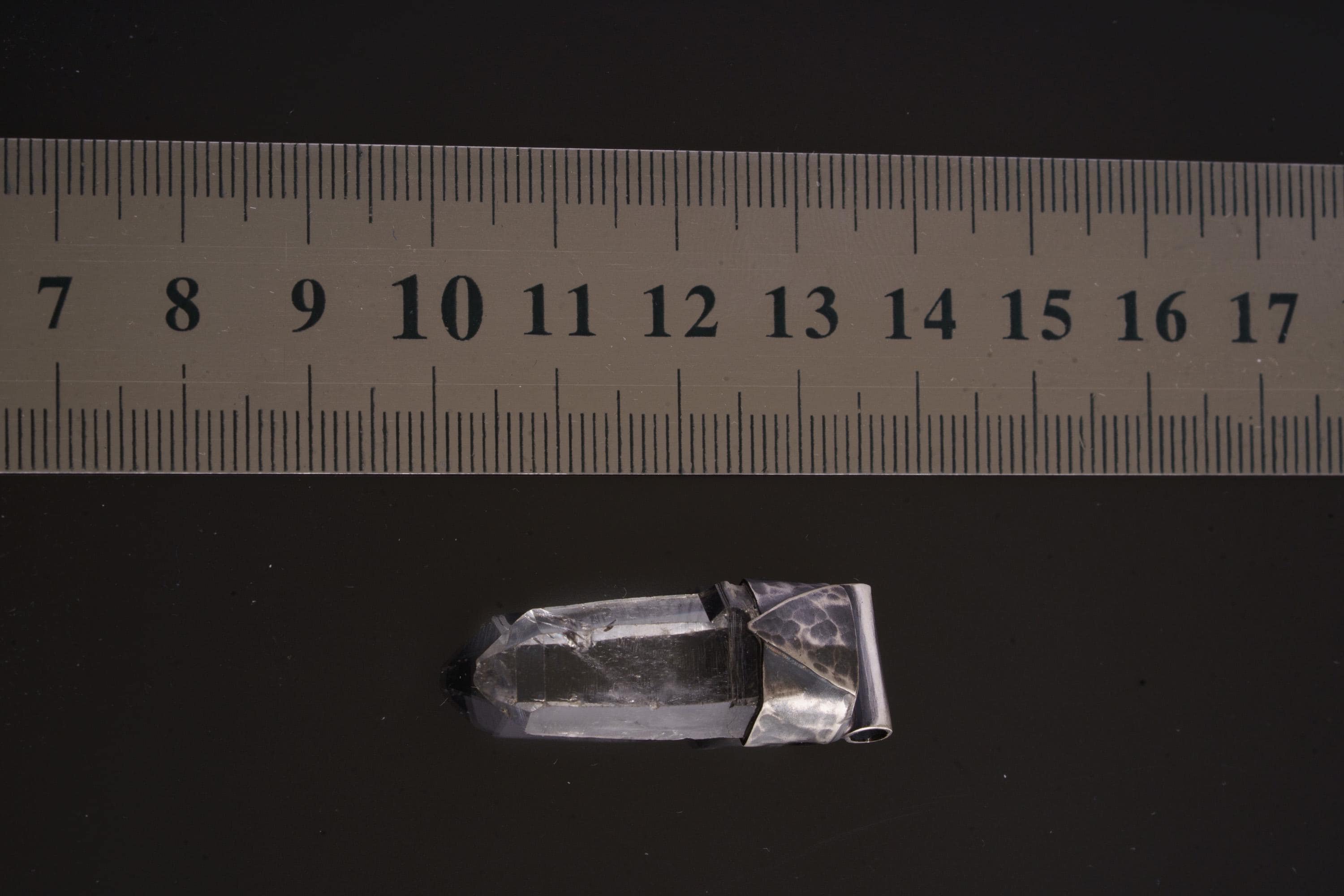 Water Clear Nepalese Inclusion Quartz pendant shown beside a ruler for scale with geometric oxidized silver cap.