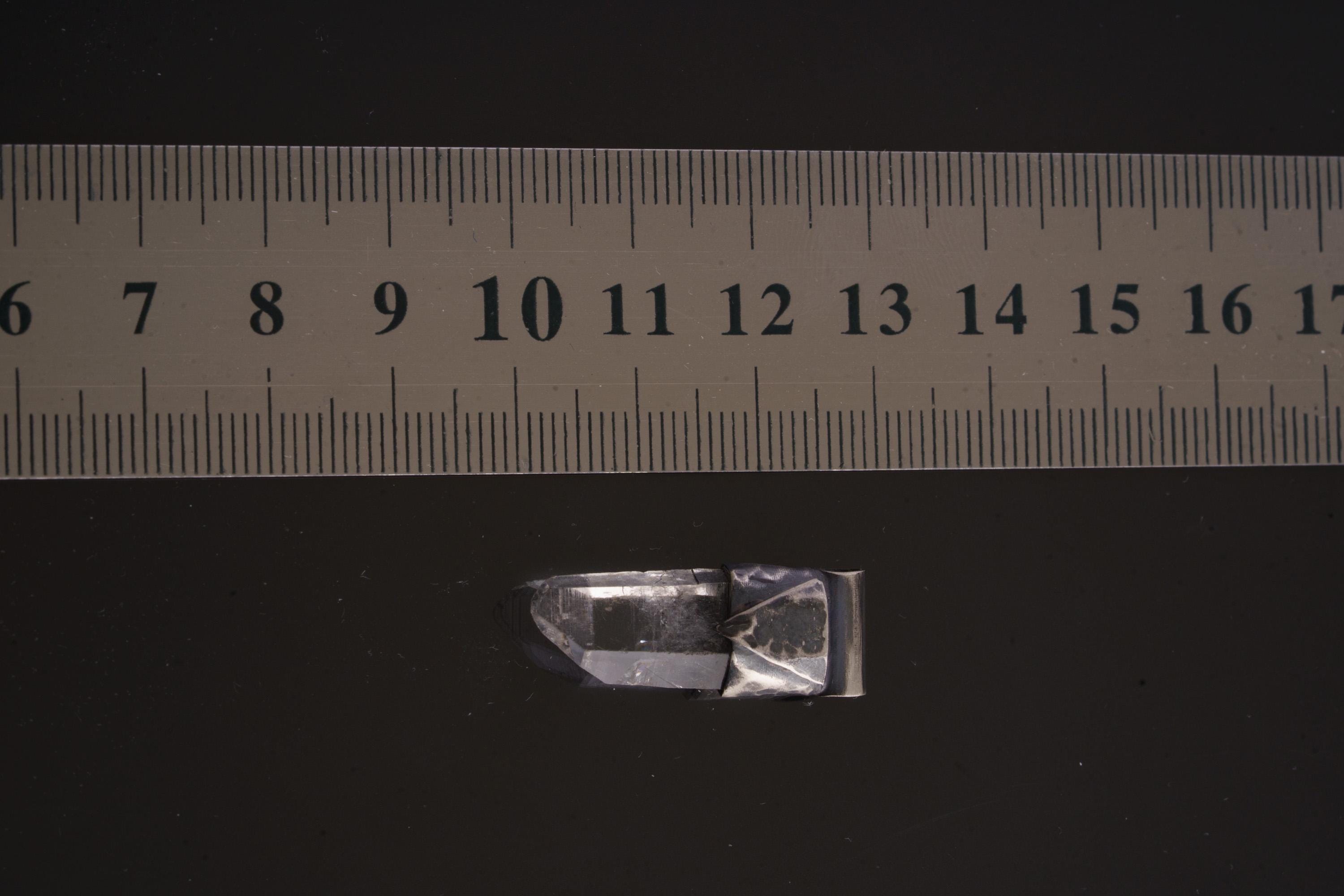 Water Clear Nepalese Inclusion Quartz Pendant shown beside a ruler for scale with oxidized silver cap and clear crystal body.