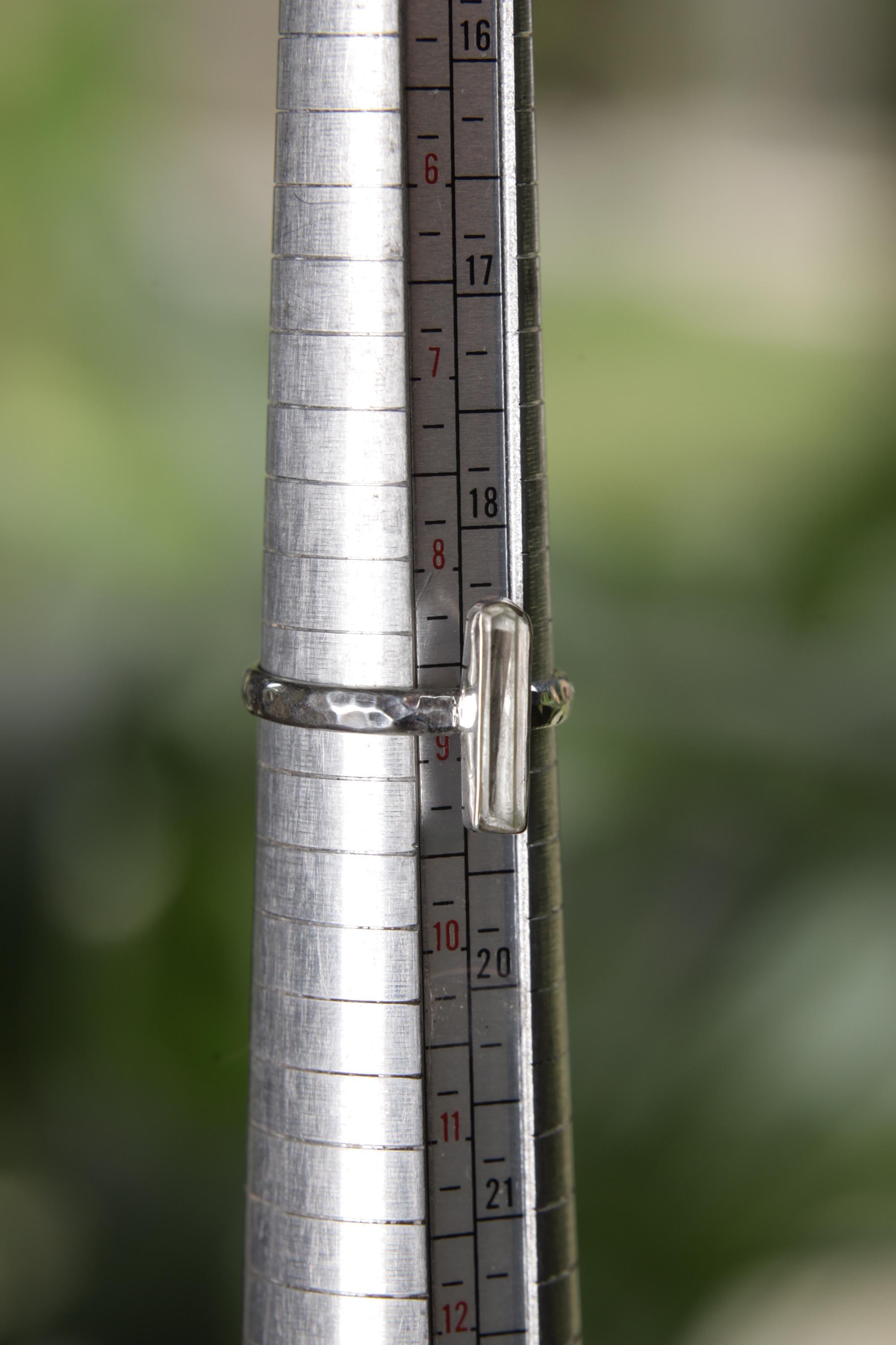 Long square cut Aquamarine ring shown on a ring mandrel for sizing, appearing around US size 8.5 to 9.