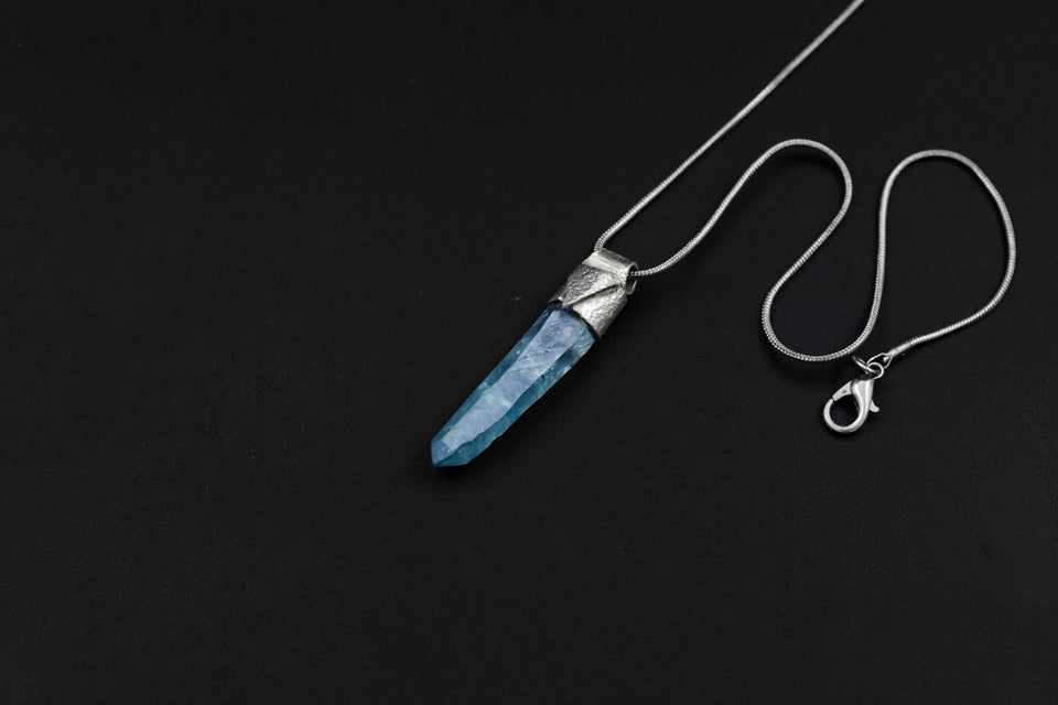 Aqua Aura Quartz Stack Pendant shown on black background with adjustable black cotton necklace and slim blue crystal point.