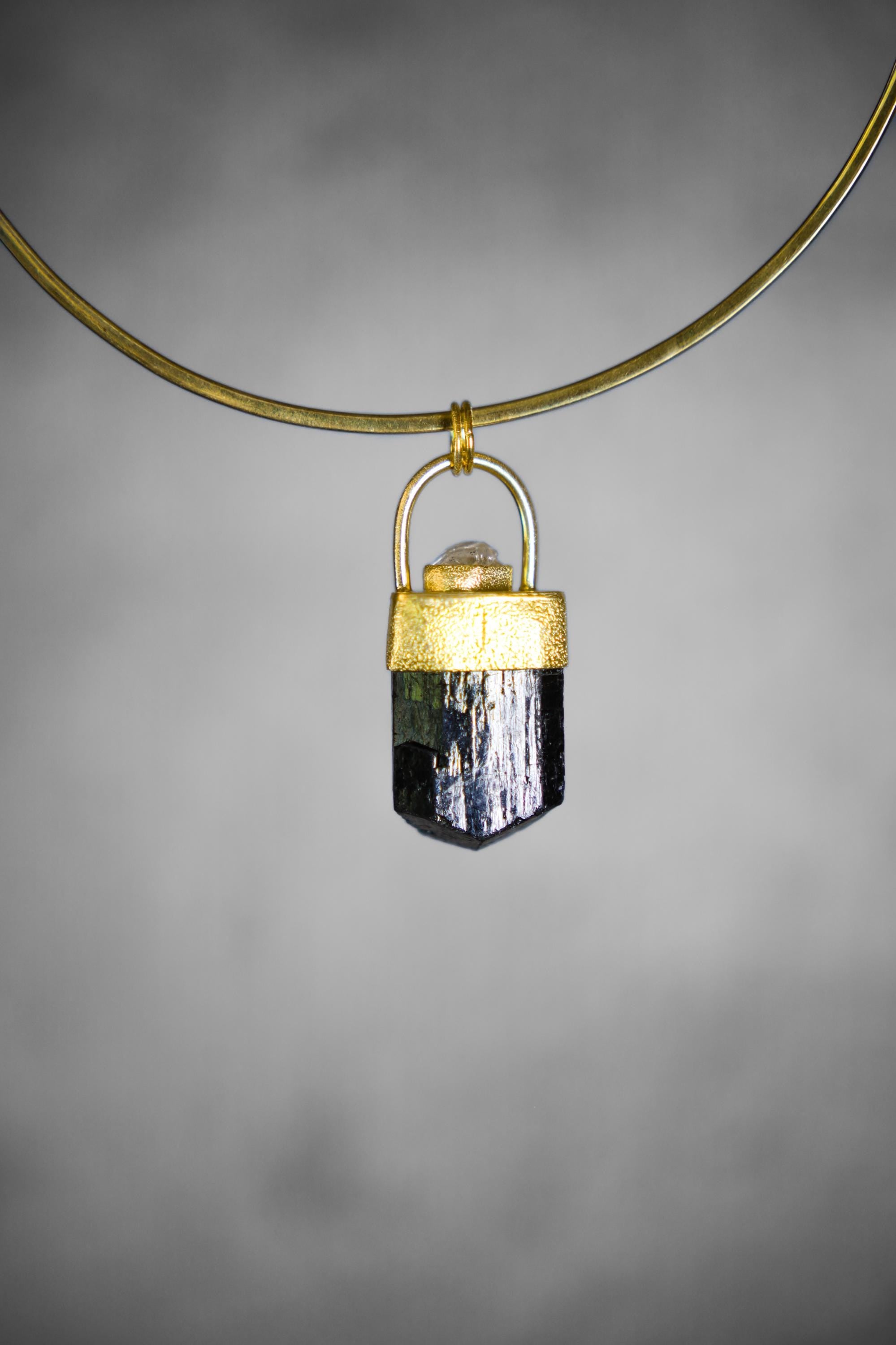 Detail view of Diamond accent set above a Himalayan Dravite Tourmaline pendant in gold-plated sterling silver.