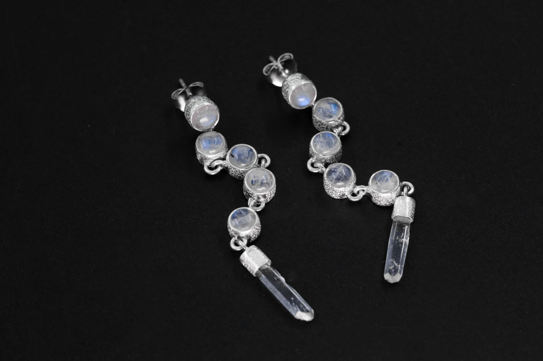 Blue Moonstone and Clear Quartz sterling silver cascade earrings shown on dark background with long crystal drops.