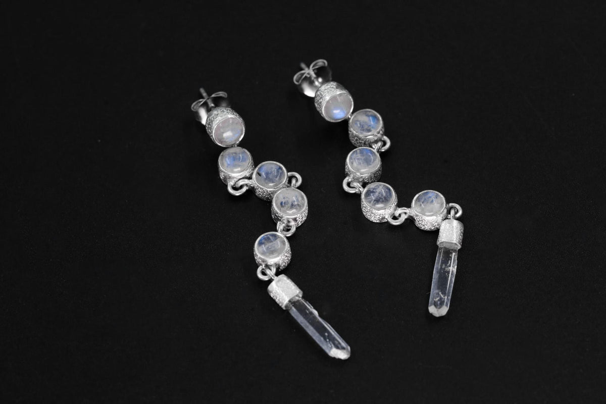 Blue Moonstone and Clear Quartz sterling silver cascade earrings shown on dark background with long crystal drops.