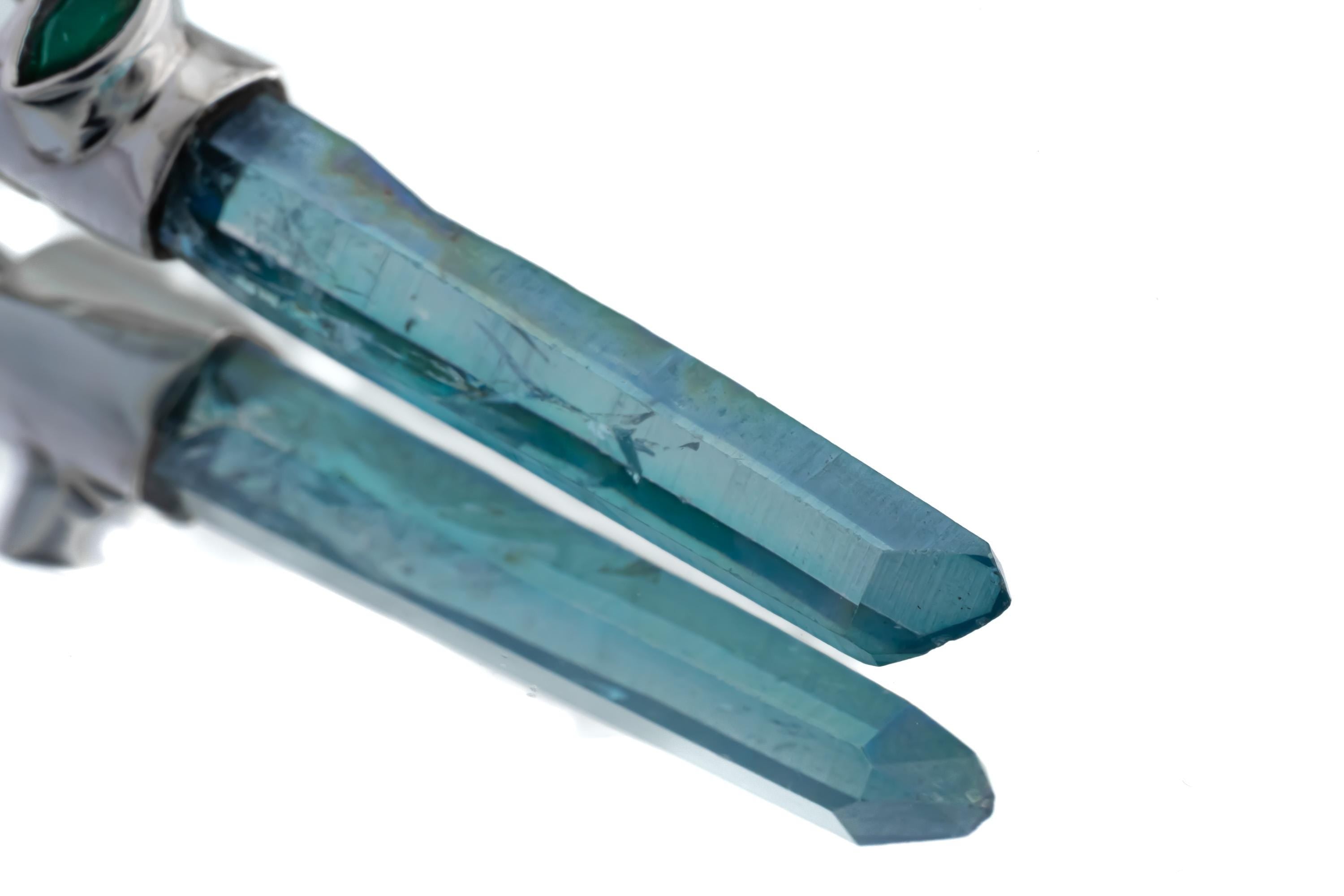 Detailed view of Aqua Aura Quartz crystal point with luminous blue sheen and polished sterling silver setting.
