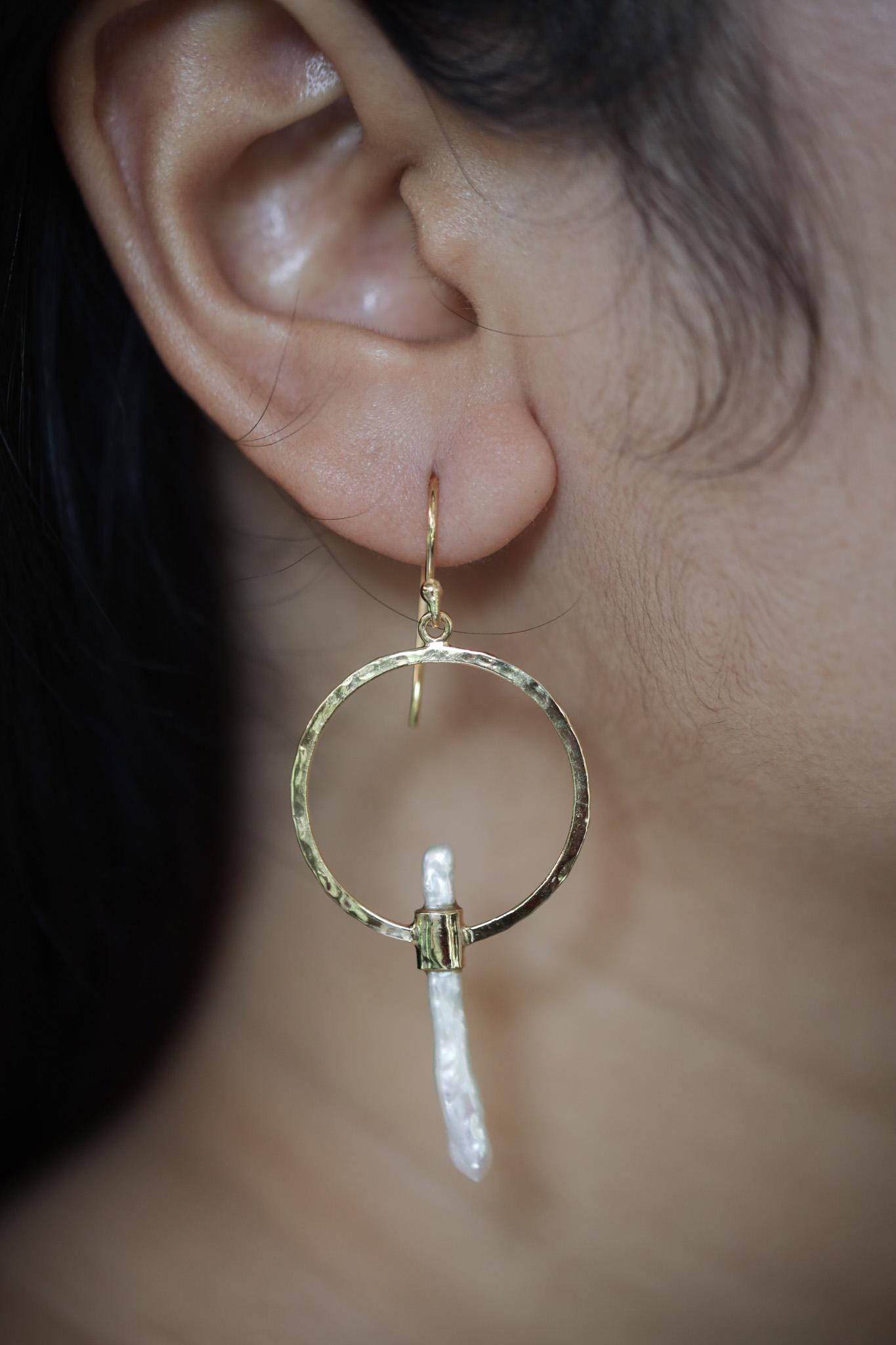 Golden Baroque Pearl earrings shown worn on a model, highlighting soft Pearl glow and circular hoop movement.