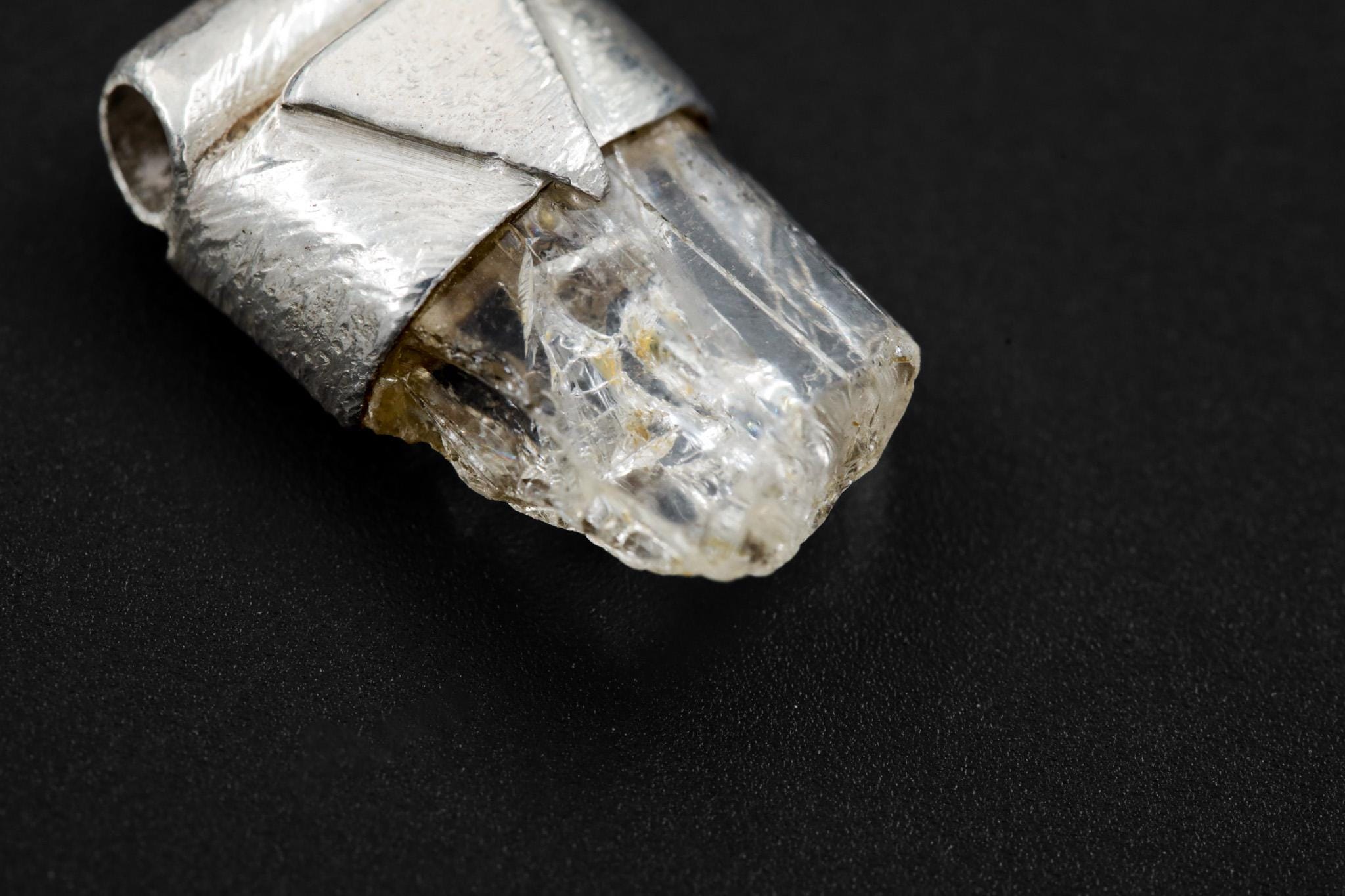 Close-up of Clear Rainbow Inclusion Spodumene showing internal rainbow flashes, raw crystal texture, and sterling silver cap.