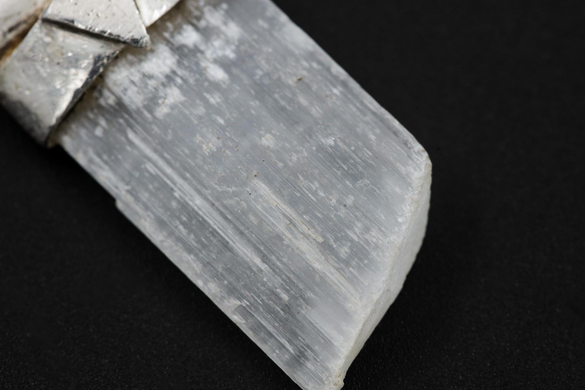 Close-up of translucent Selenite with natural layered texture and hand-textured sterling silver cap.