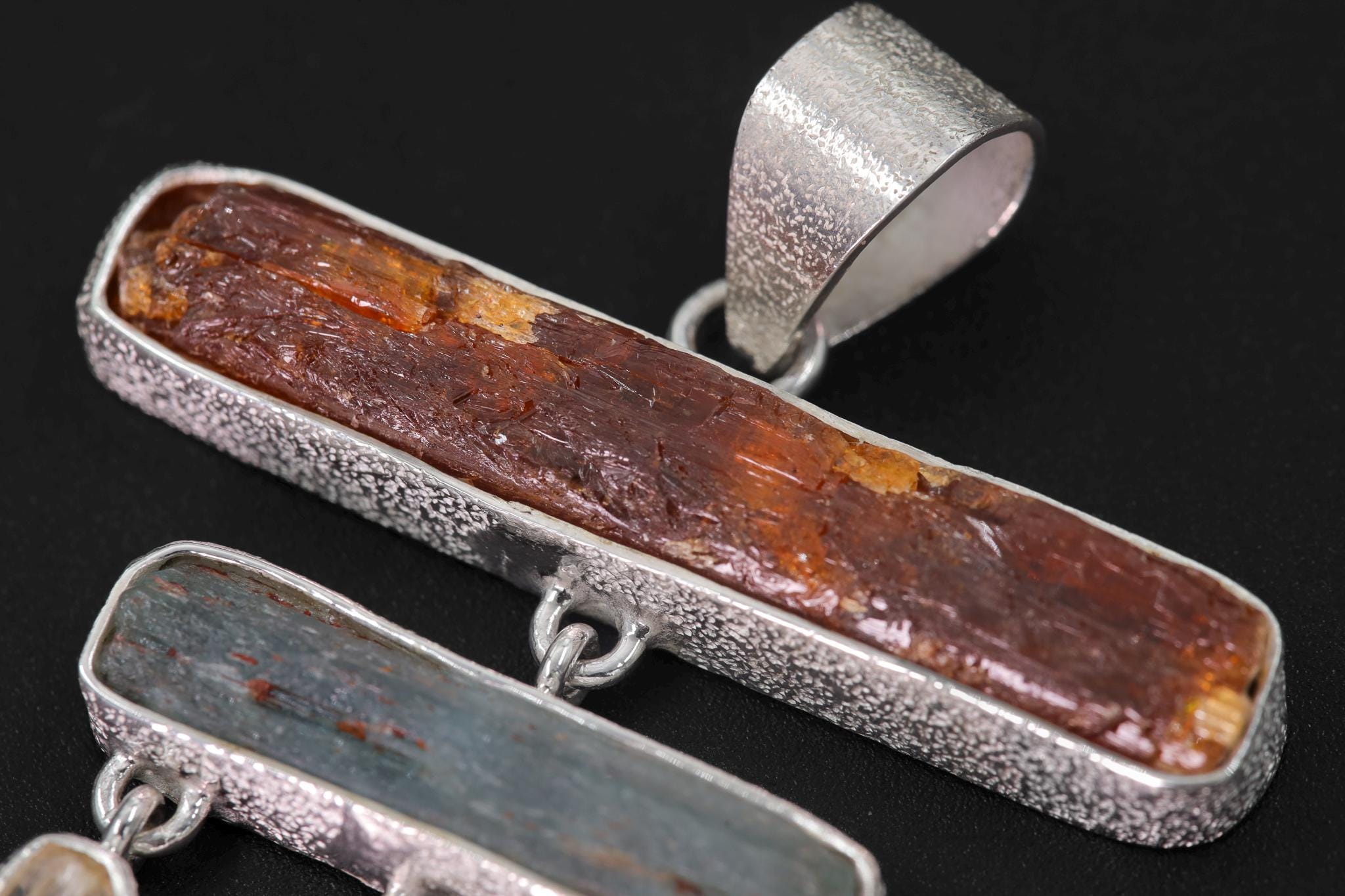 Close-up of Red Kyanite and Aquamarine in a handmade sterling silver fire and water talisman pendant.