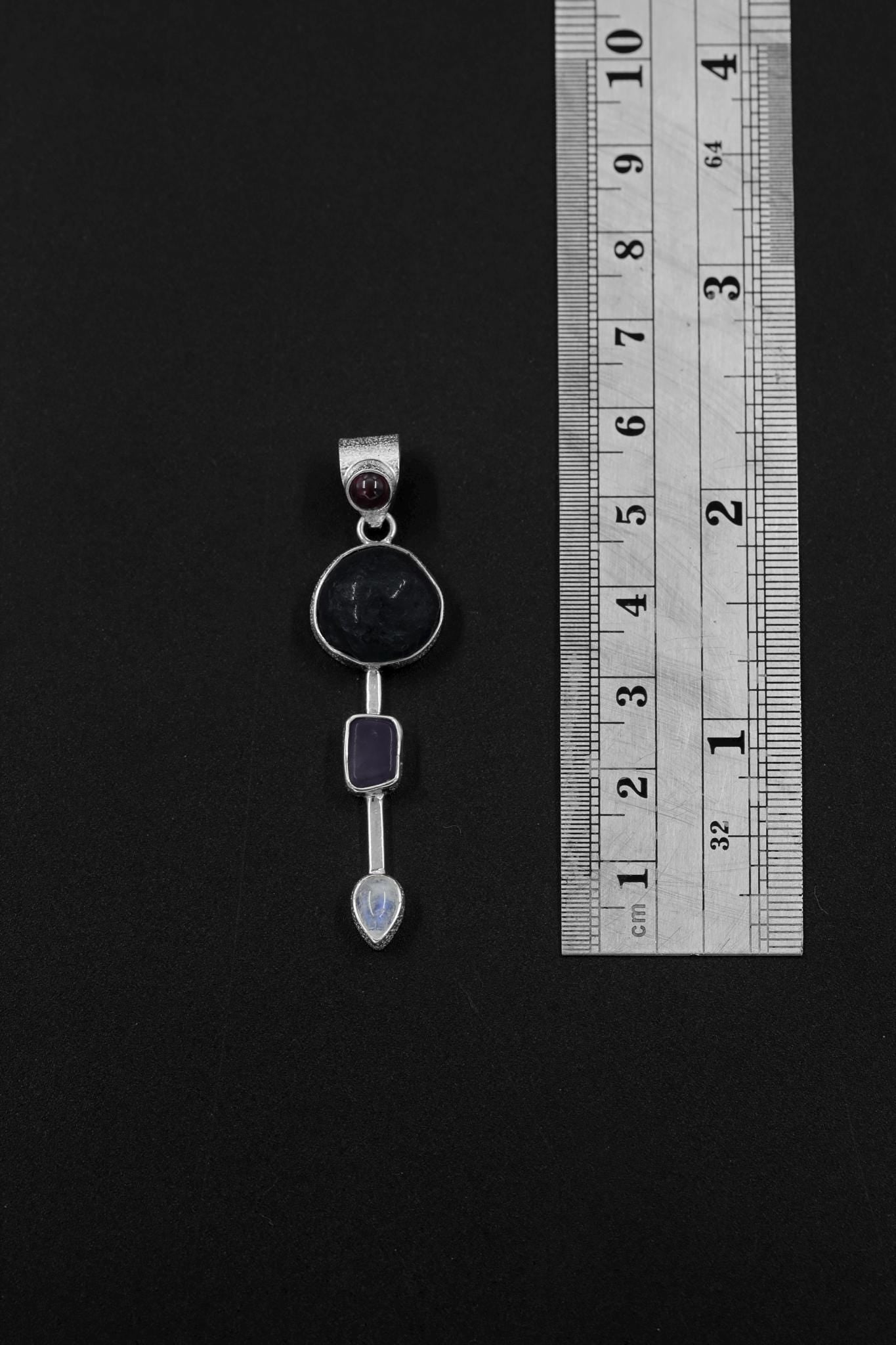 Celestial Impact Talisman shown beside a ruler for scale, measuring approximately 6 cm long with four-stone vertical layout.