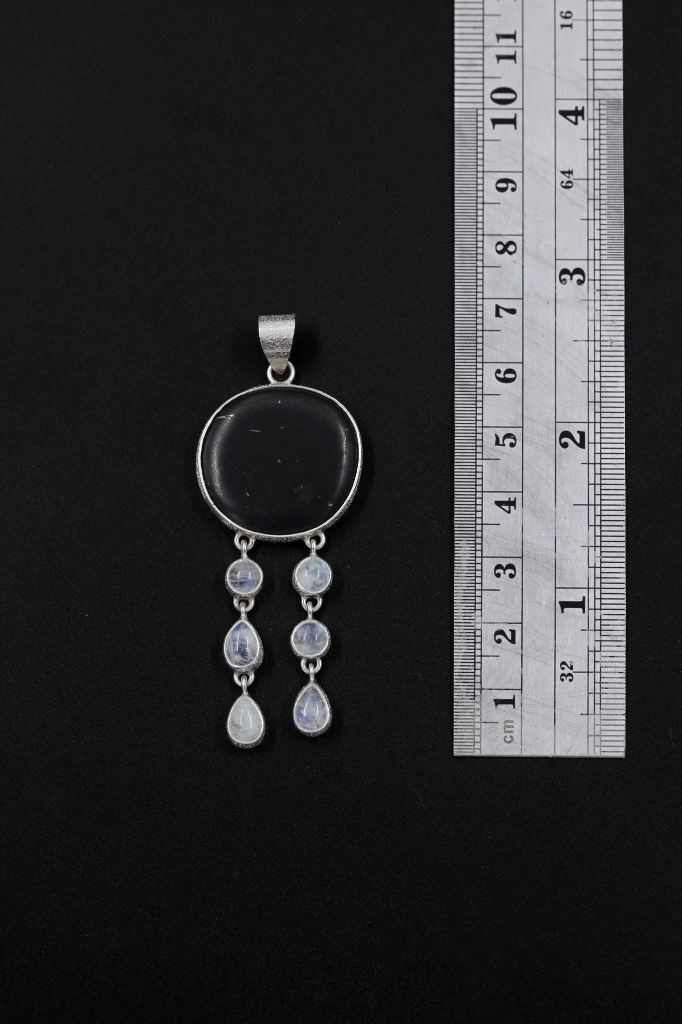 Shungite Blue Moonstone pendant shown beside a ruler for scale, measuring approximately 6.5 cm total length.