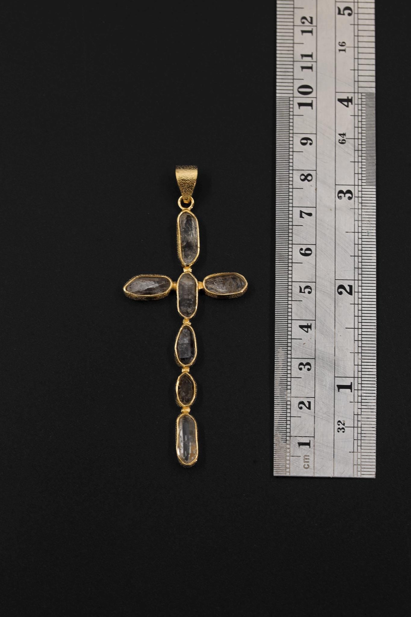 Petroleum Smoky Quartz cross pendant shown beside a ruler for scale, measuring approximately 7.3 cm long and 4 cm wide.