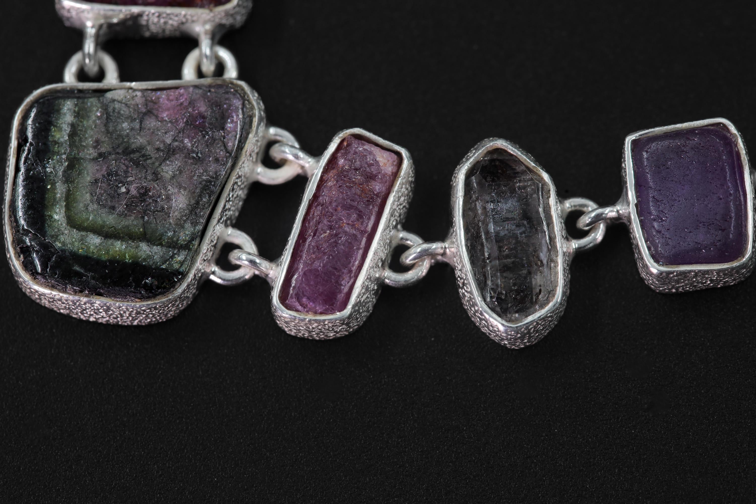 Close-up of Green Tourmaline, raw Ruby, and Petroleum Quartz stones in high-polish 925 sterling silver bezels.