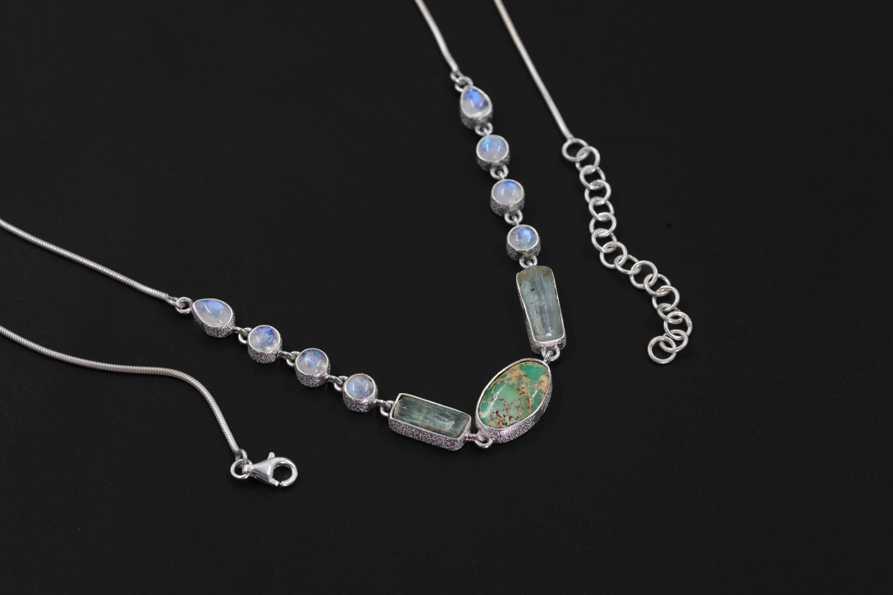 Sleeping Beauty Turquoise Aquamarine Rainbow Moonstone necklace shown on a dark background with sterling silver snake chain.