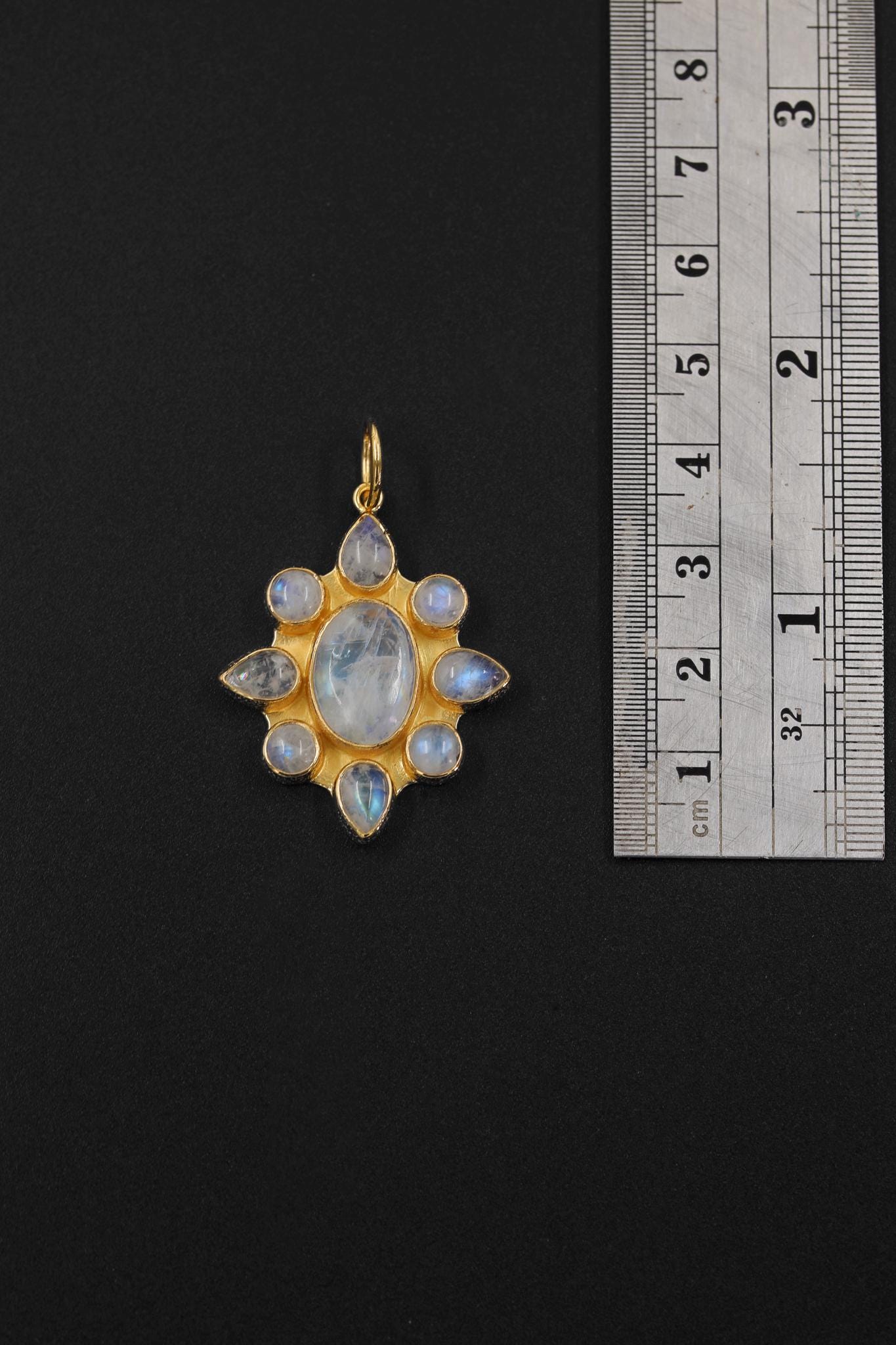 Blue Moonstone flower pendant shown beside a ruler for scale, measuring approximately 3.2 cm including bail.