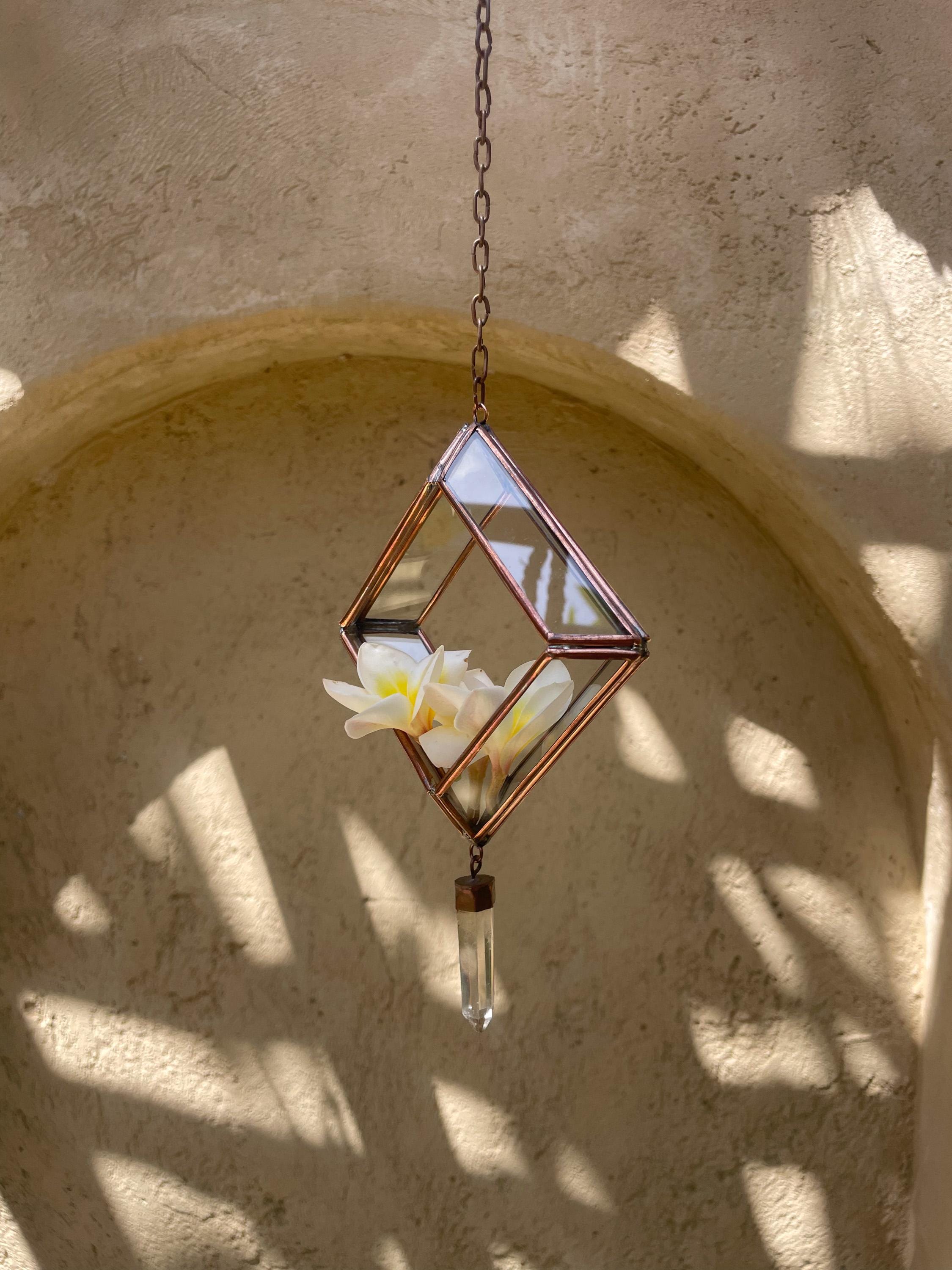 Copper Quartz rectangle ornament hanging in sunlight, with transparent glass panels and raw Clear Quartz crystal.