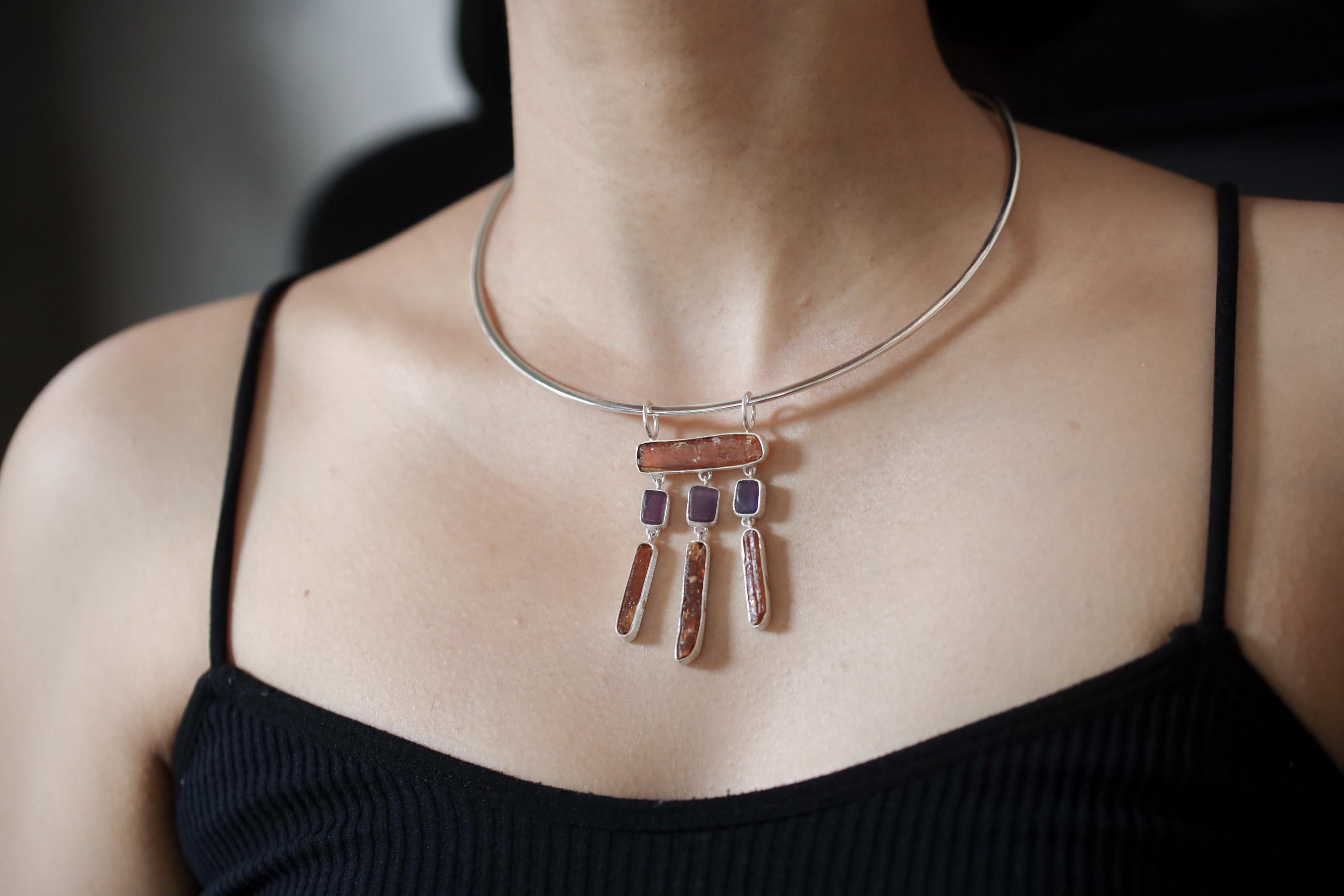 Oracle of Embers pendant shown worn on a model, with red and violet stones in a statement sterling silver dangle design.