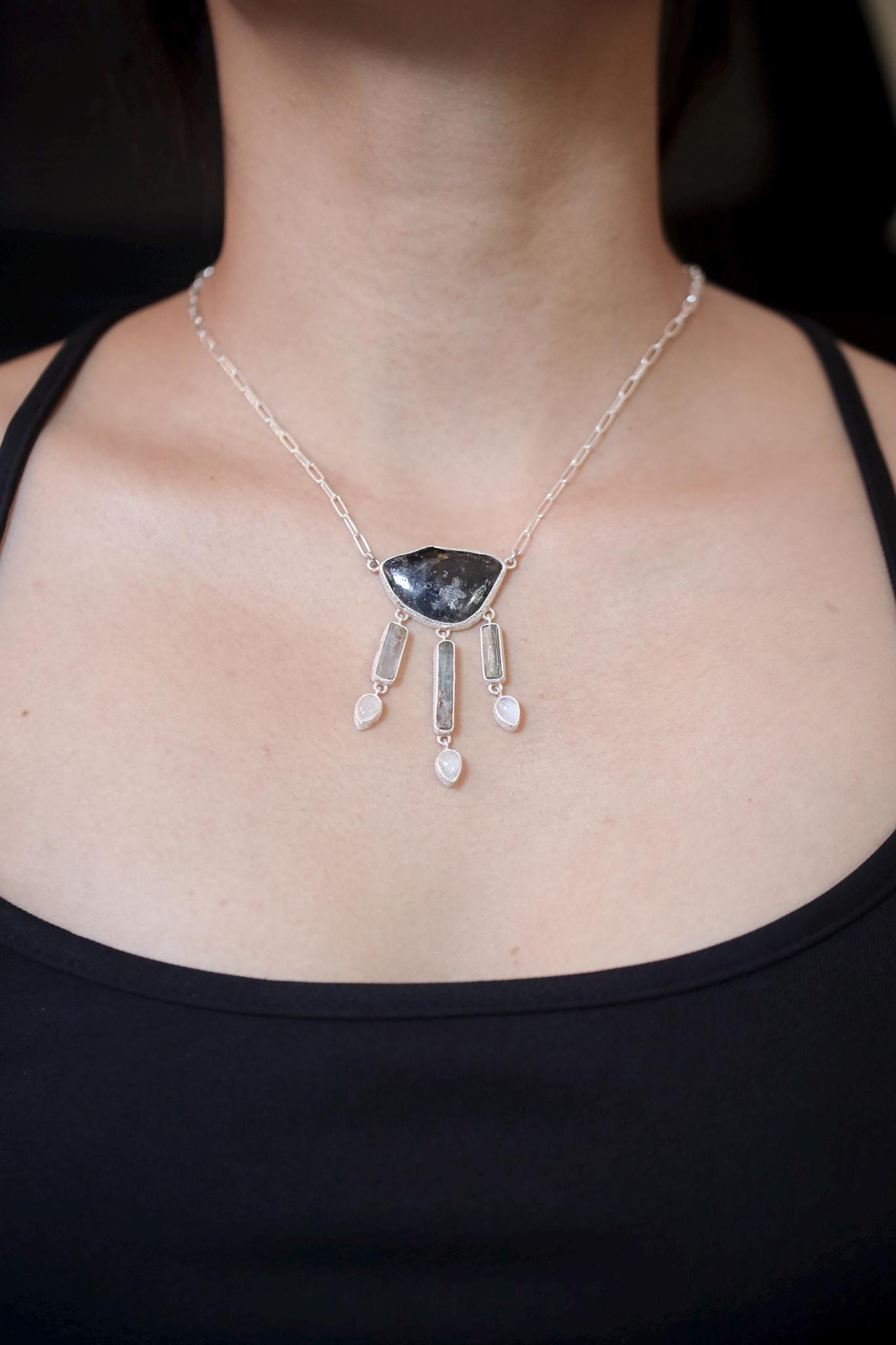 Celestial Waters Cascade necklace shown worn on the chest, with Blue Tourmaline, Aquamarine, Angel Aura Quartz, Moonstone, and sterling silver.