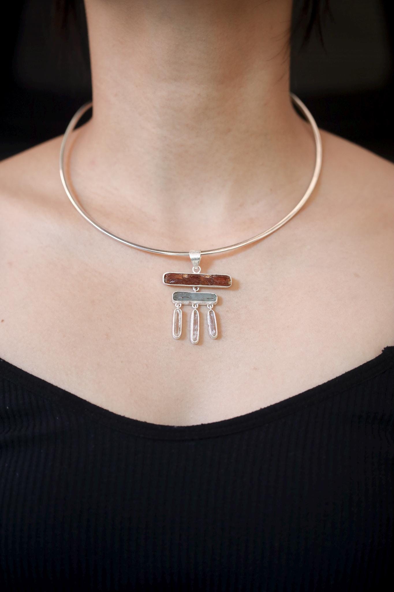 Flame and Tide Harmony pendant shown worn on the chest, with raw Red Kyanite, Aquamarine, and three Clear Quartz dangles.