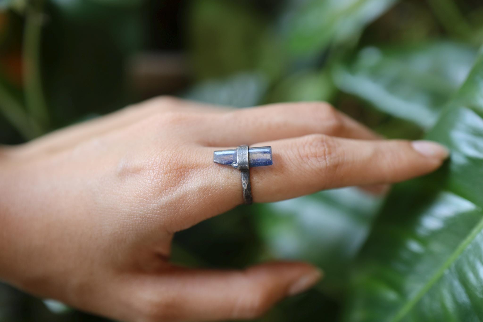 Raw Kyanite ring shown worn on the hand as a deep blue Throat Chakra crystal ring in oxidized sterling silver.