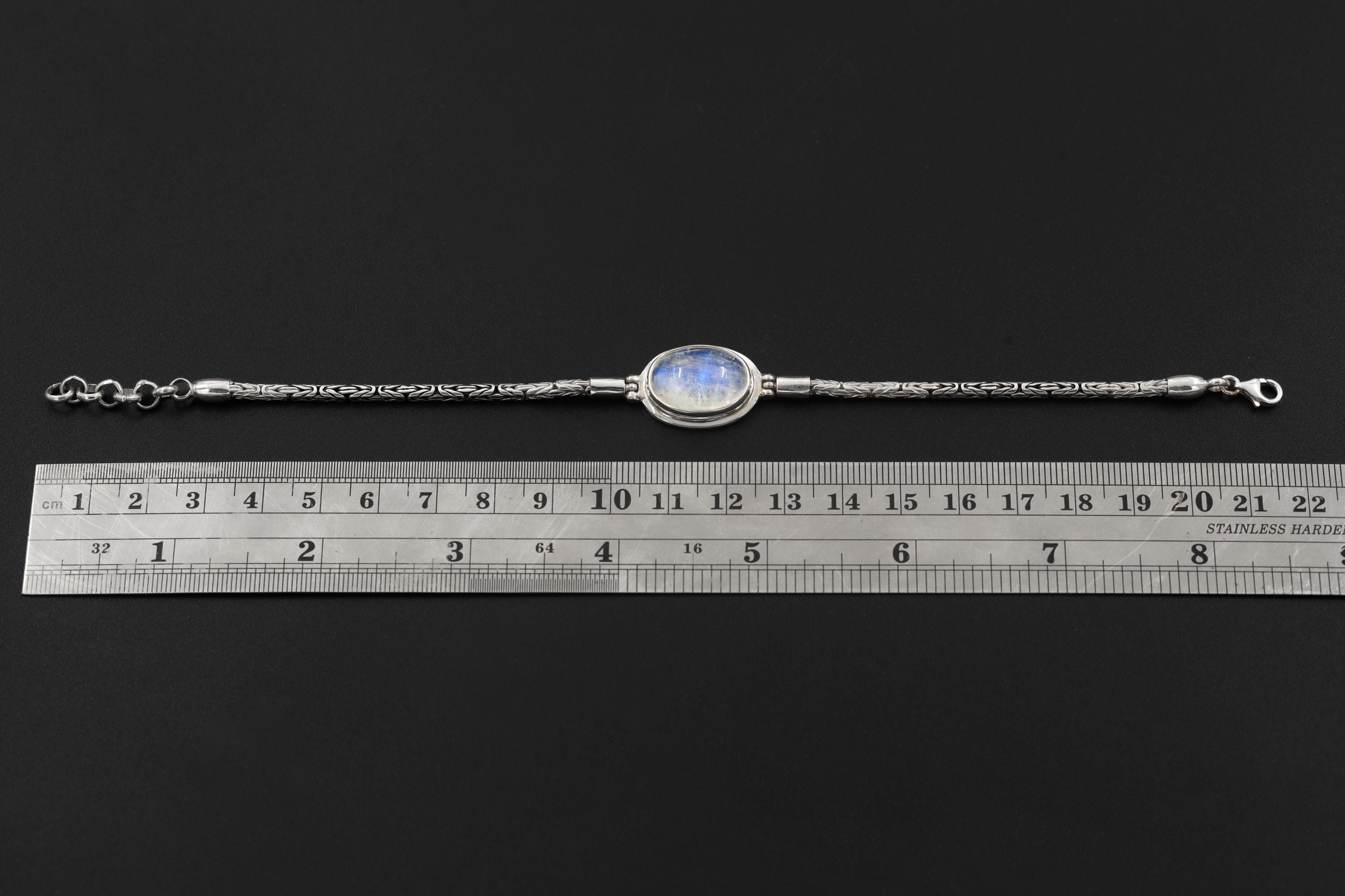 Blue Moonstone sterling silver bracelet shown beside a ruler for adjustable 18 to 21 cm length reference.