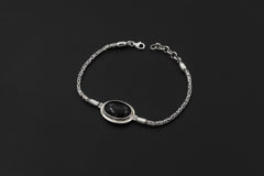 Black Onyx sterling silver Byzantine bracelet shown on dark background beside a ruler for adjustable length reference.