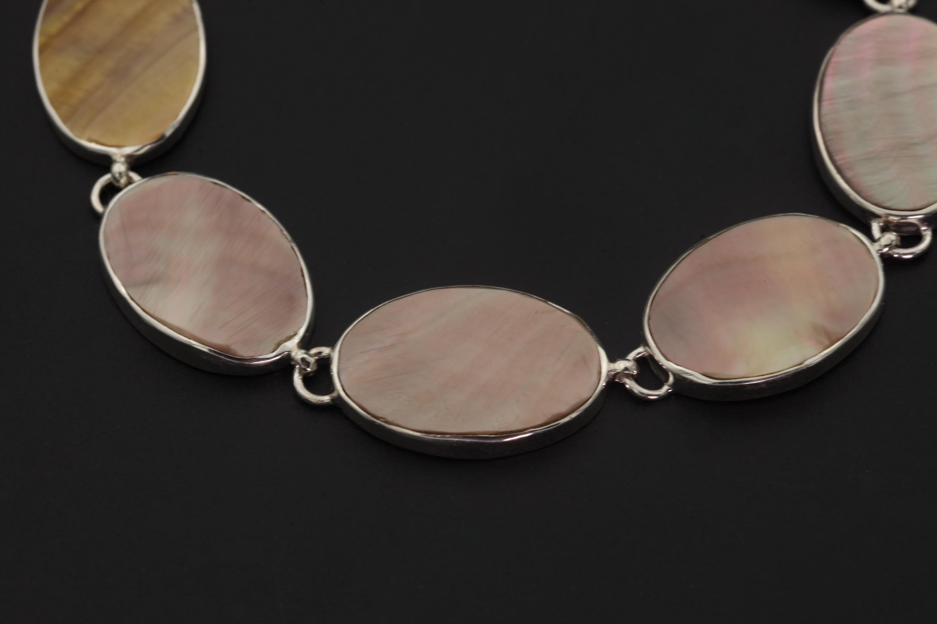 Close view of Mother of Pearl bracelet showing pastel nacre glow in polished sterling silver bezel settings.