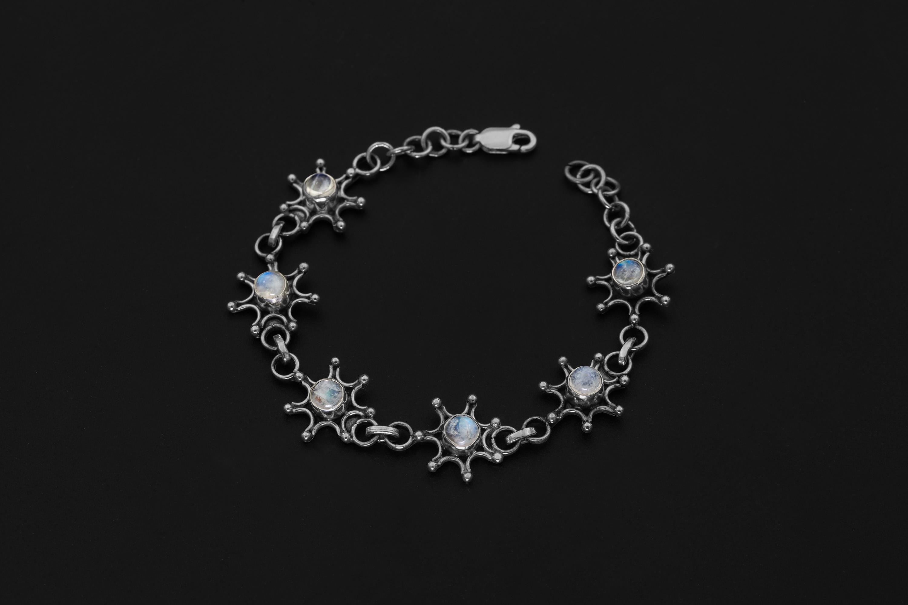 Celestial Blue Moonstone bracelet displayed on dark background with polished sterling silver starburst settings.