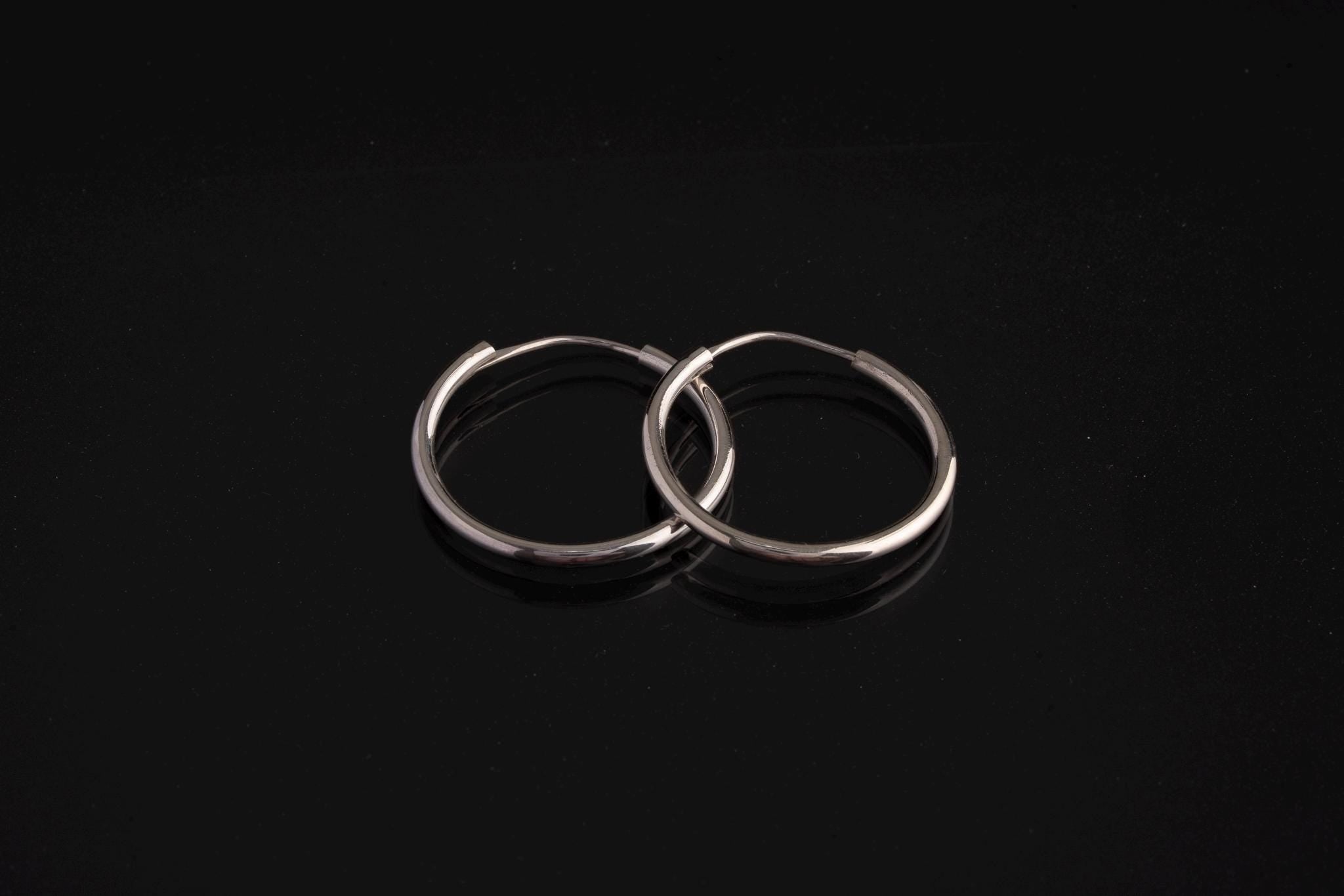 Polished sterling silver Opal hoop earrings shown on a dark background with removable leaf pendant charms.