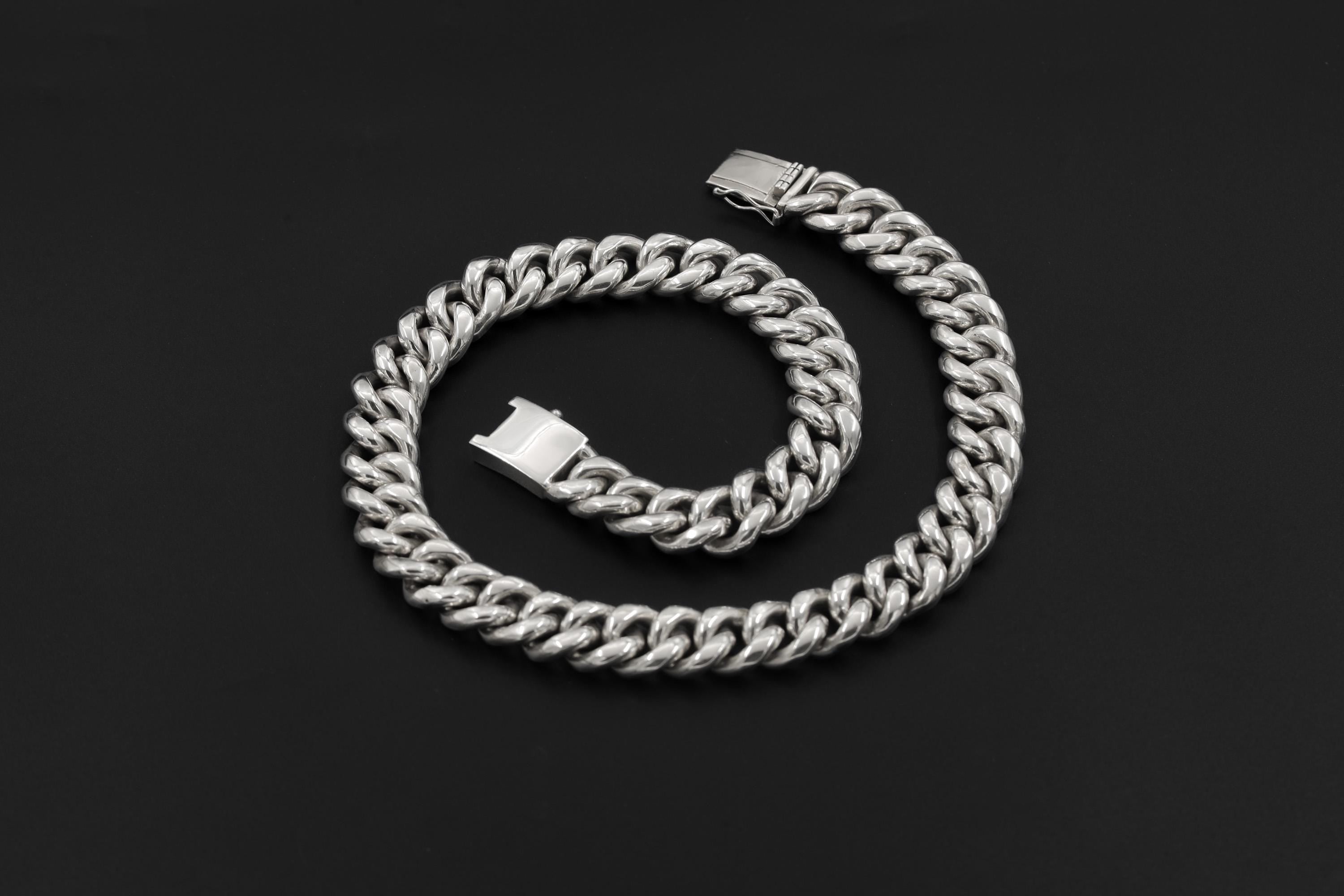 Solid 925 sterling silver woven chain bracelet displayed coiled on black background.
