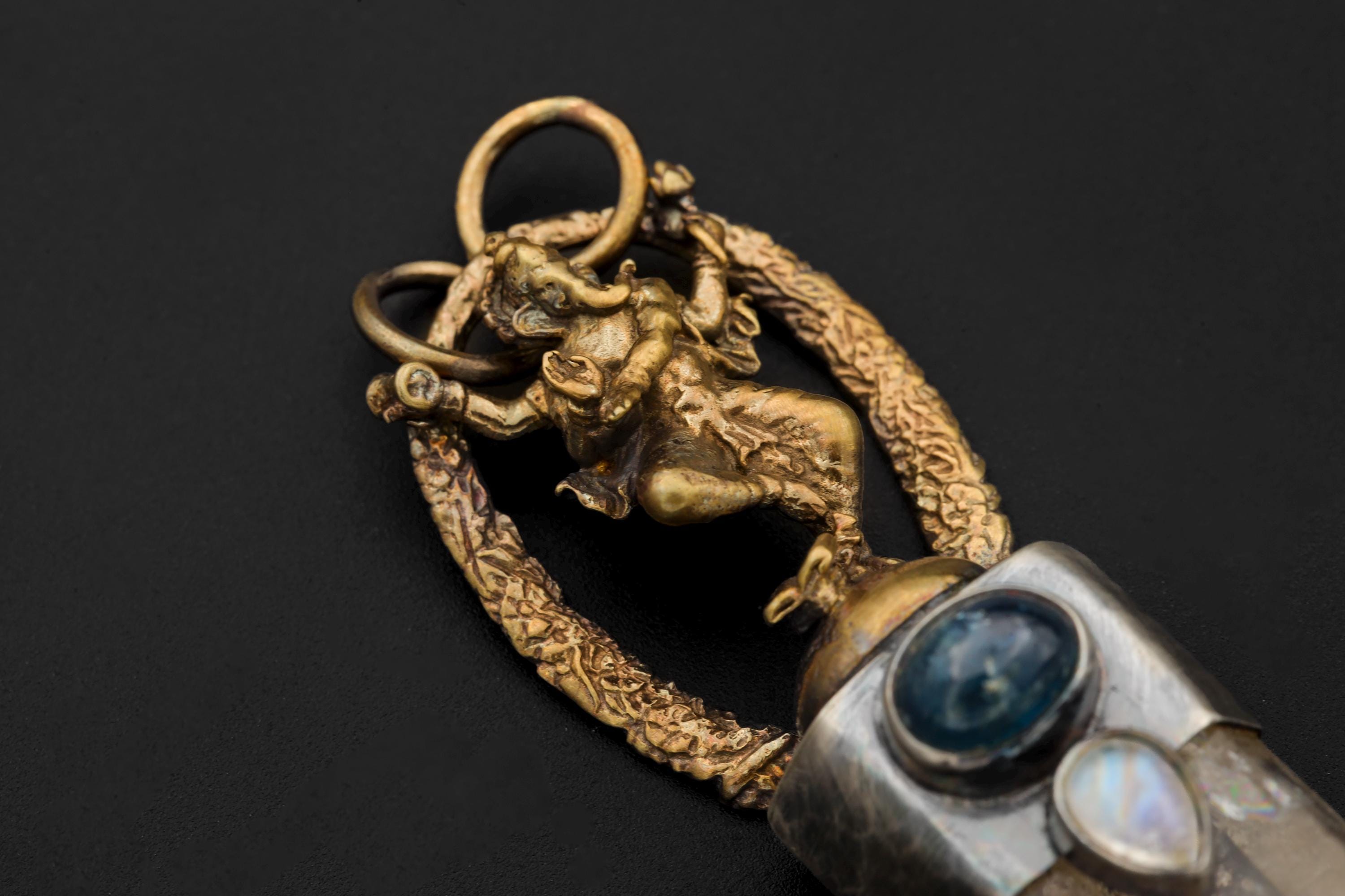 Artistic dim-light capture emphasizing transparency of quartz point and halo glow of moonstone.