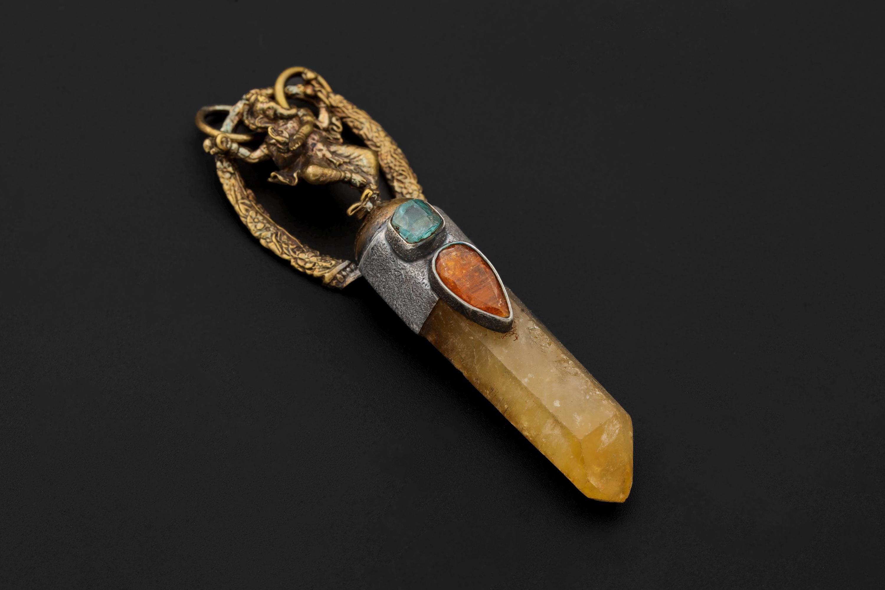 Ganesha Citrine Quartz Brass Cast Gold Plated Talisman Pendant on black background featuring gold-plated brass Ganesha figure, faceted orange Gem Kyanite, raw Gem Apatite, and natural Citrine Quartz point set in oxidized textured silver bezel.
