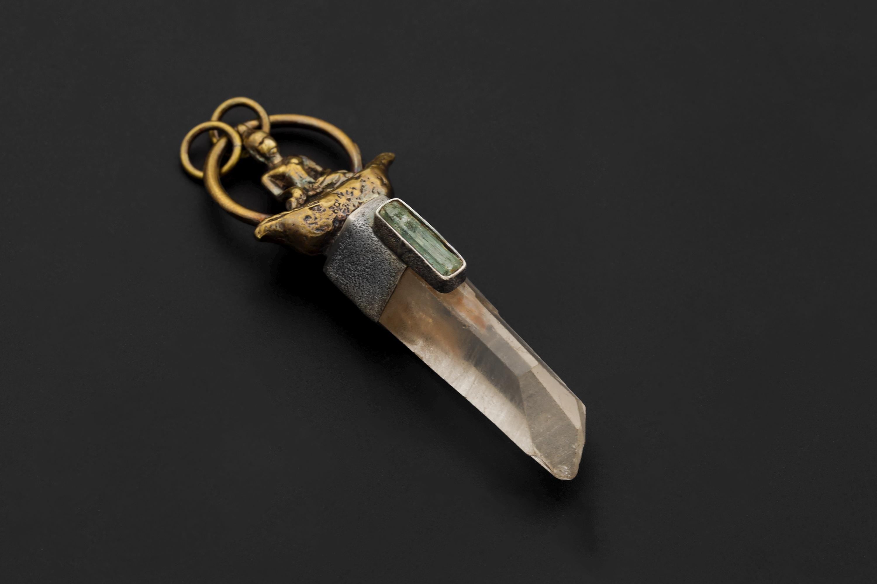 Pendant laid flat to display complete construction from Buddha figure top to pointed quartz termination.