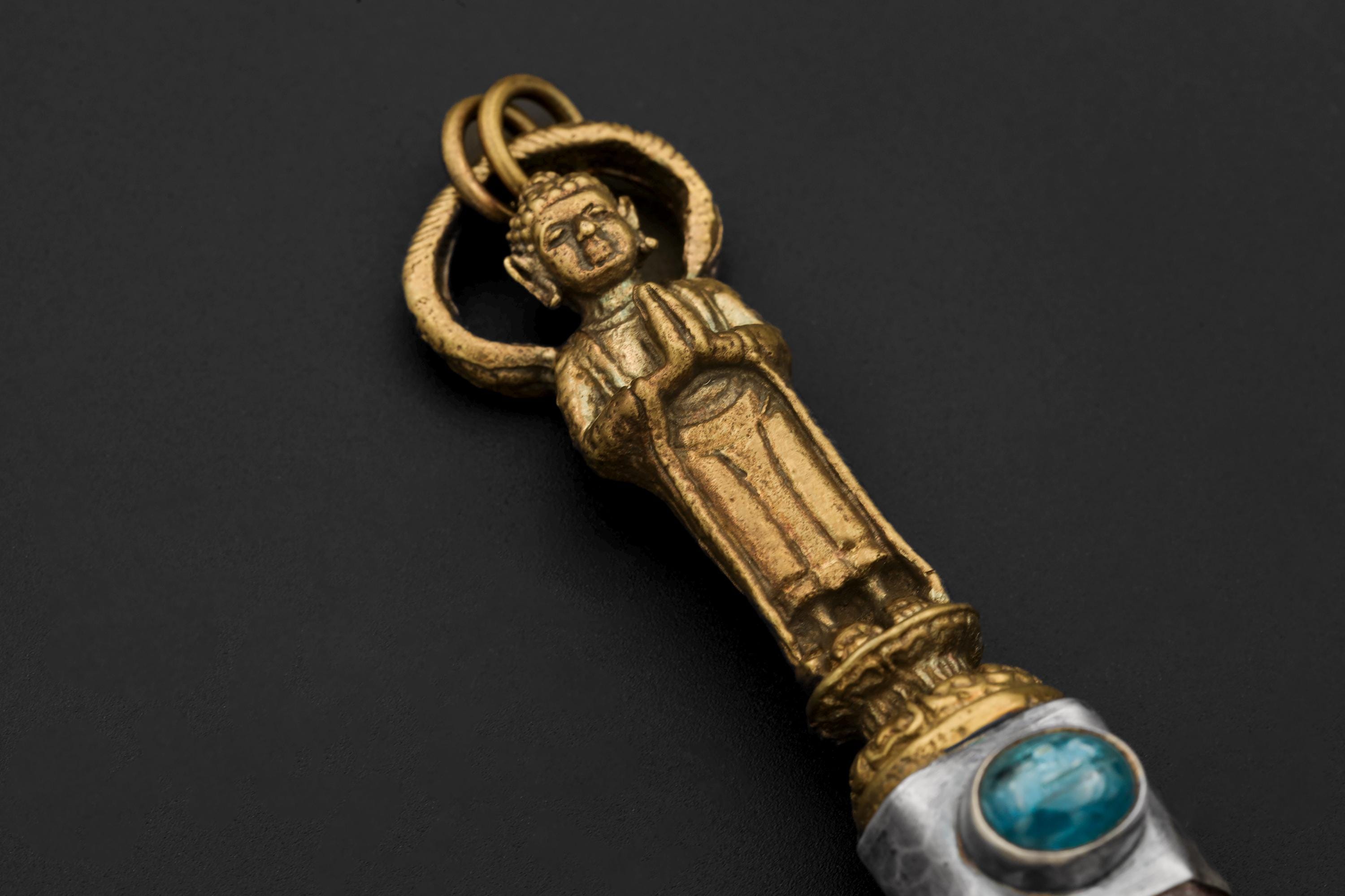 Close-up of gold-plated Buddha figure and Australian Ocean Kyanite cabochon in hammered sterling silver bezel.