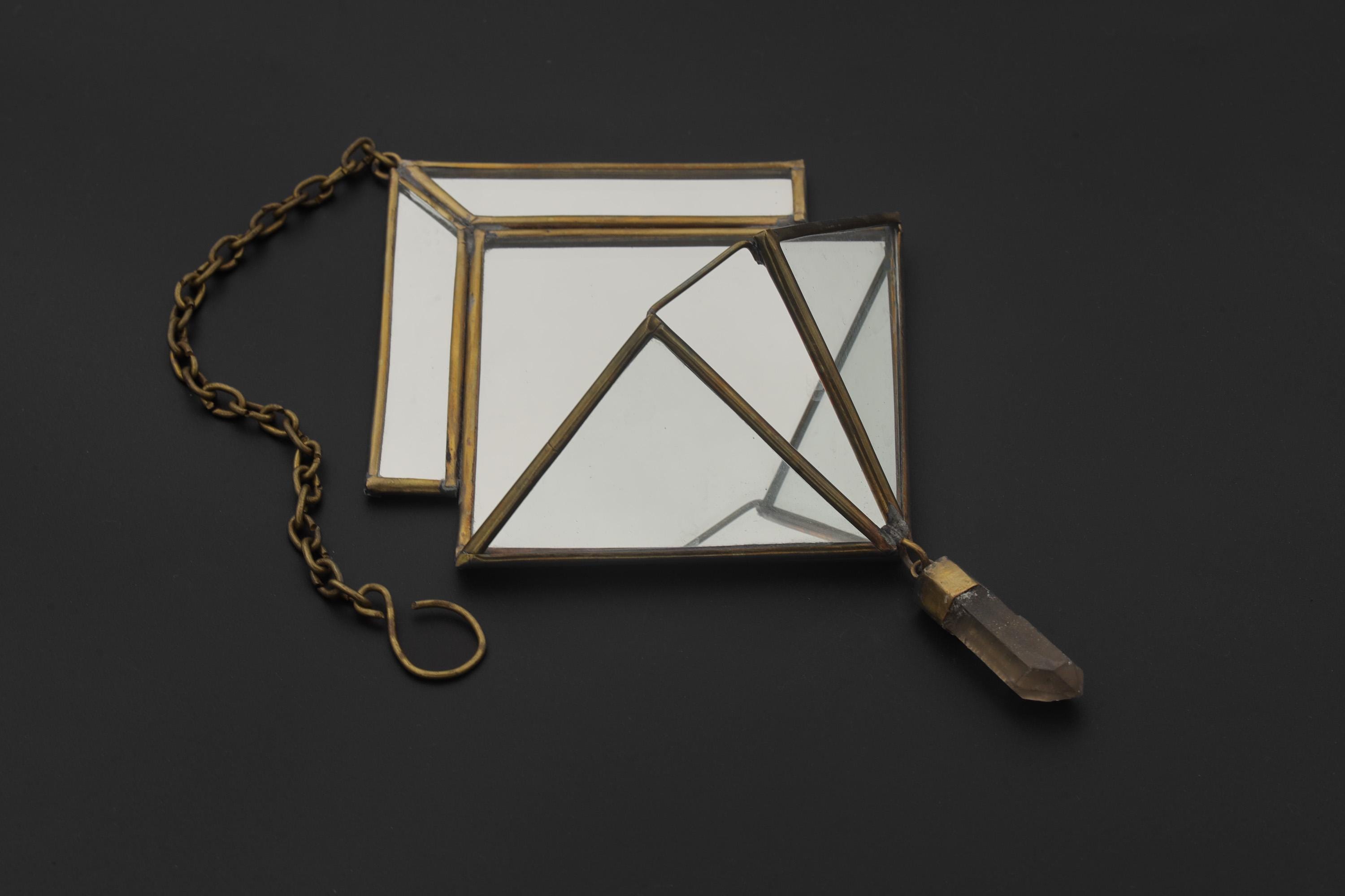 Quartz Reliquary hanging decoration displayed on dark background with aged brass frame, mirrored panels, and crystal drop.