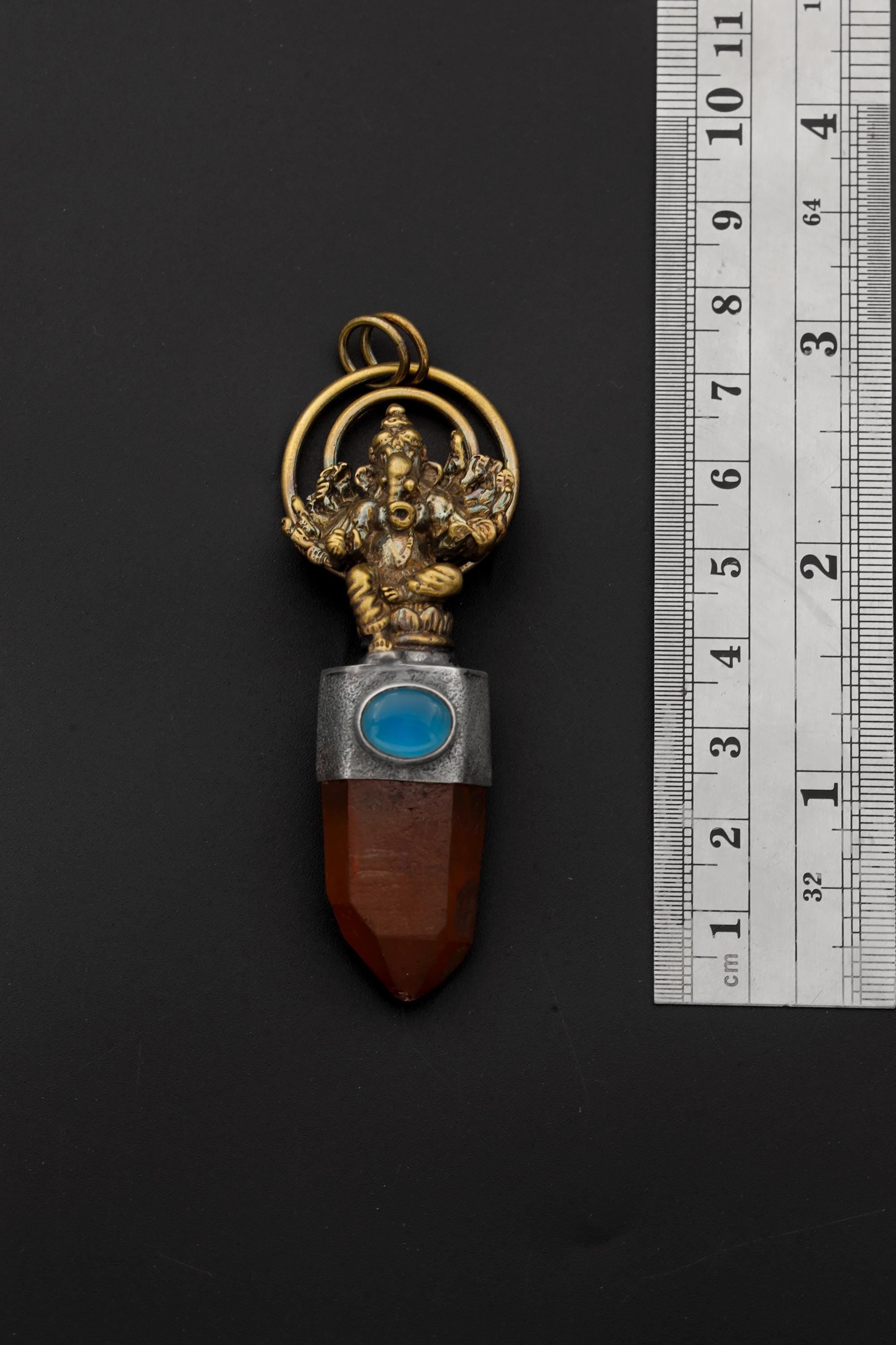 Ganesha Lithium Quartz Aquamarine pendant shown beside a ruler for scale, measuring approximately 7.5 cm including loop.