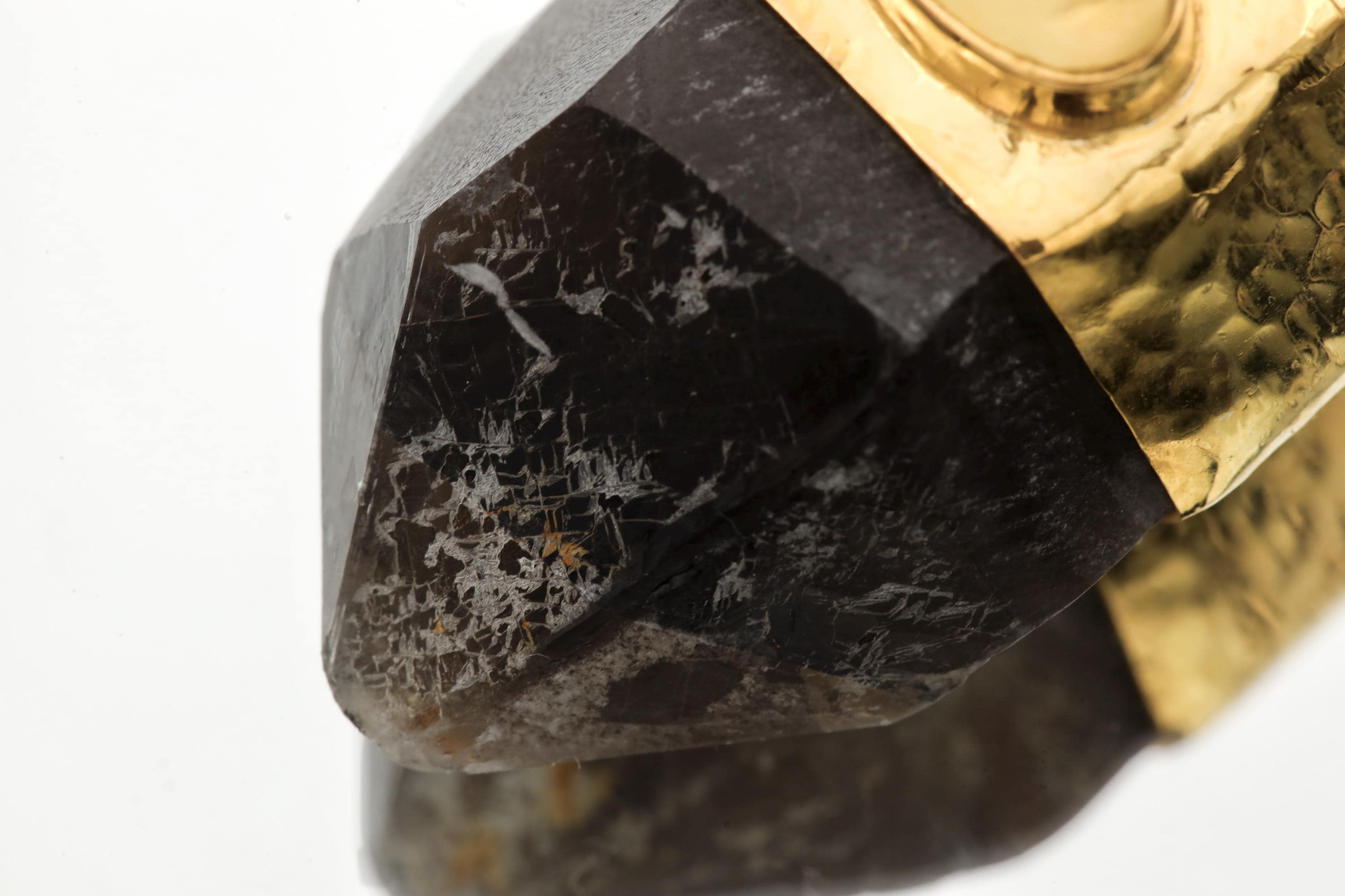 Pendant laid flat displaying Record Keeper triangular etchings on quartz termination and handcrafted metal texture.