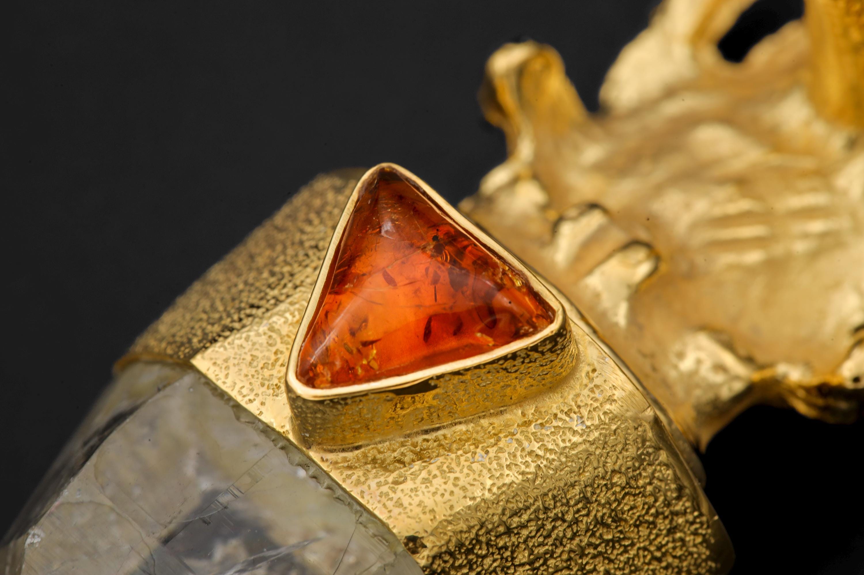 Macro image focusing on Rainbow Pyrite shimmer within quartz and texture of 18K gold-plated bezel.Macro image focusing on Rainbow Pyrite shimmer within quartz and texture of 18K gold-plated bezel.