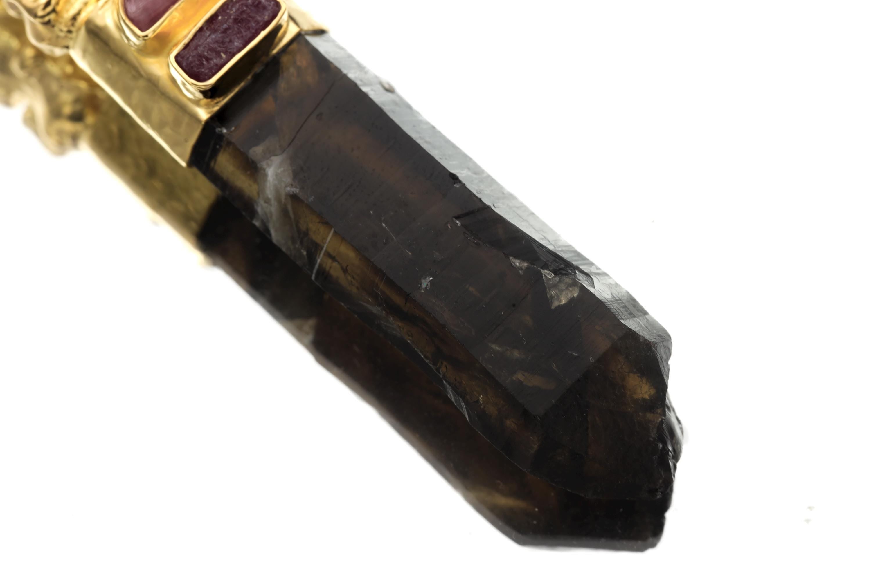 Close-up of tourmaline gemstone bezel highlighting magenta-pink hue and polished facets set in silver frame.