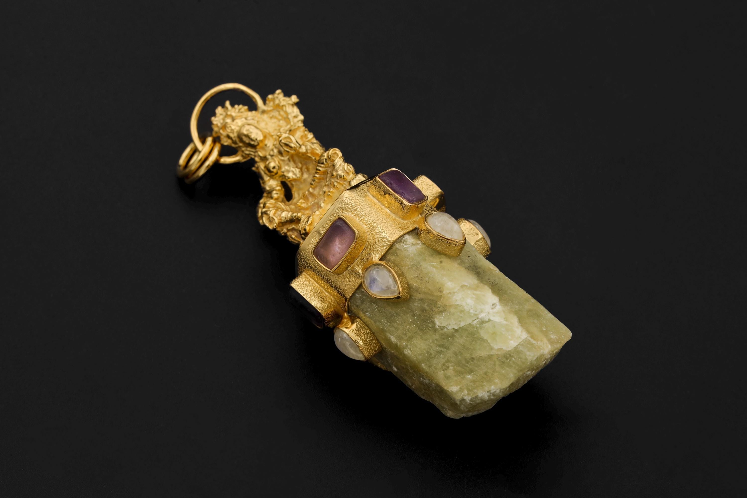 Cast Brass Talisman pendant on black background featuring intricate gold-plated brass sculpture above a chunky natural Australian Aquamarine wand with Amethyst Quartz square stones and Blue Moonstone cabochons set in 925 silver bezel.