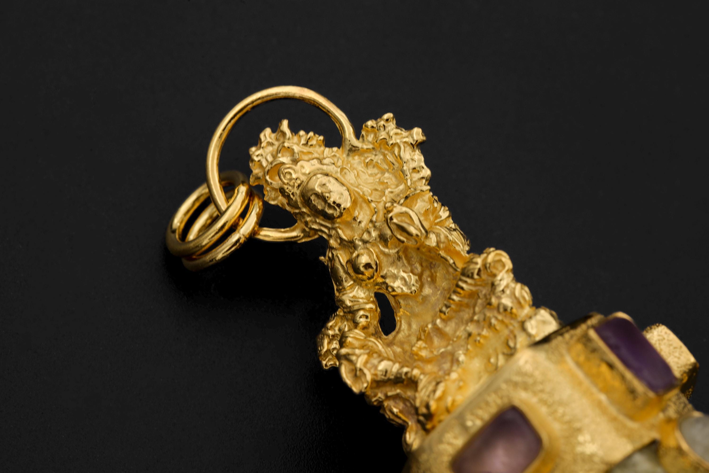 Close-up of brass casting showing hand-textured patterns, symbolic design, and gold-plated sheen.