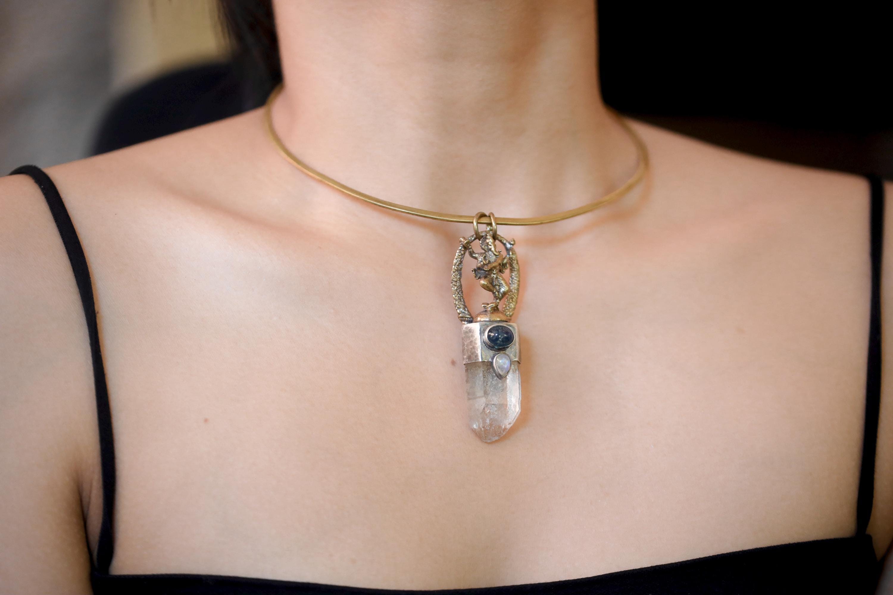 Pendant worn at neck with focus on balance between brass Ganesha and silver bezel contrast.