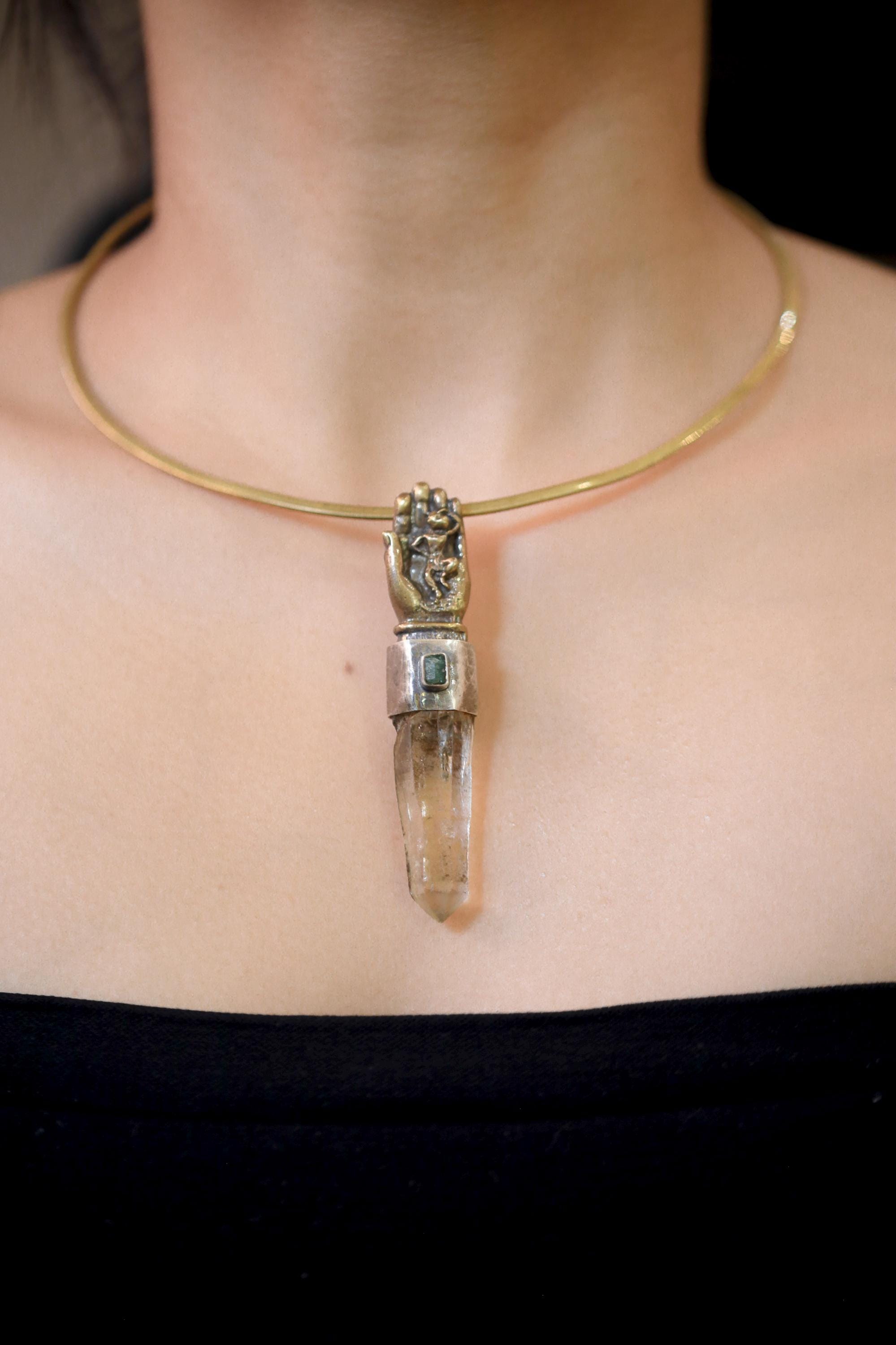 Pendant on model neckline viewed from side showing proportional drop and reflective facets of quartz.