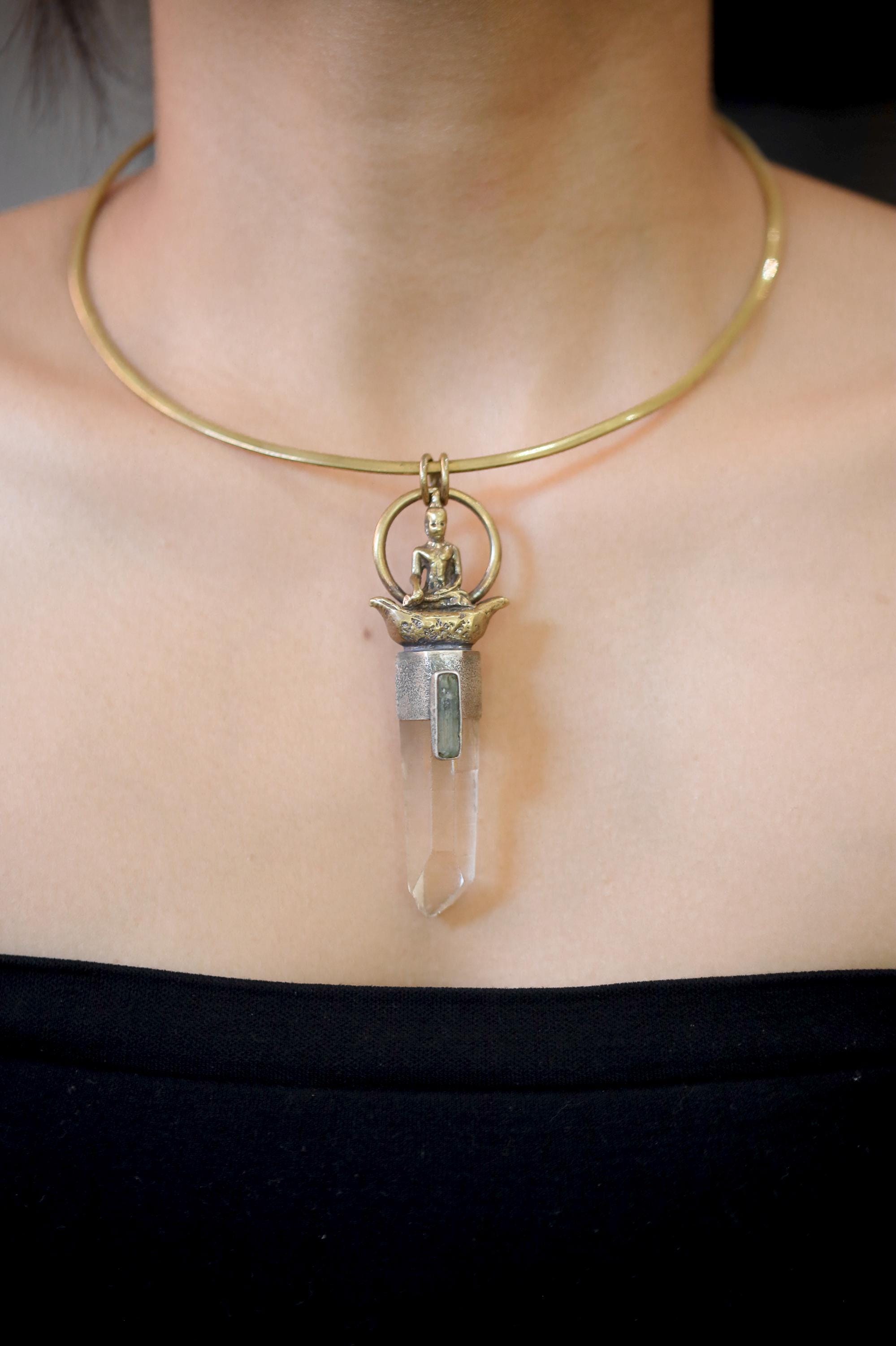 Buddha Lemurian Window Quartz Aquamarine pendant shown worn on the chest with gold-toned brass and clear crystal point.
