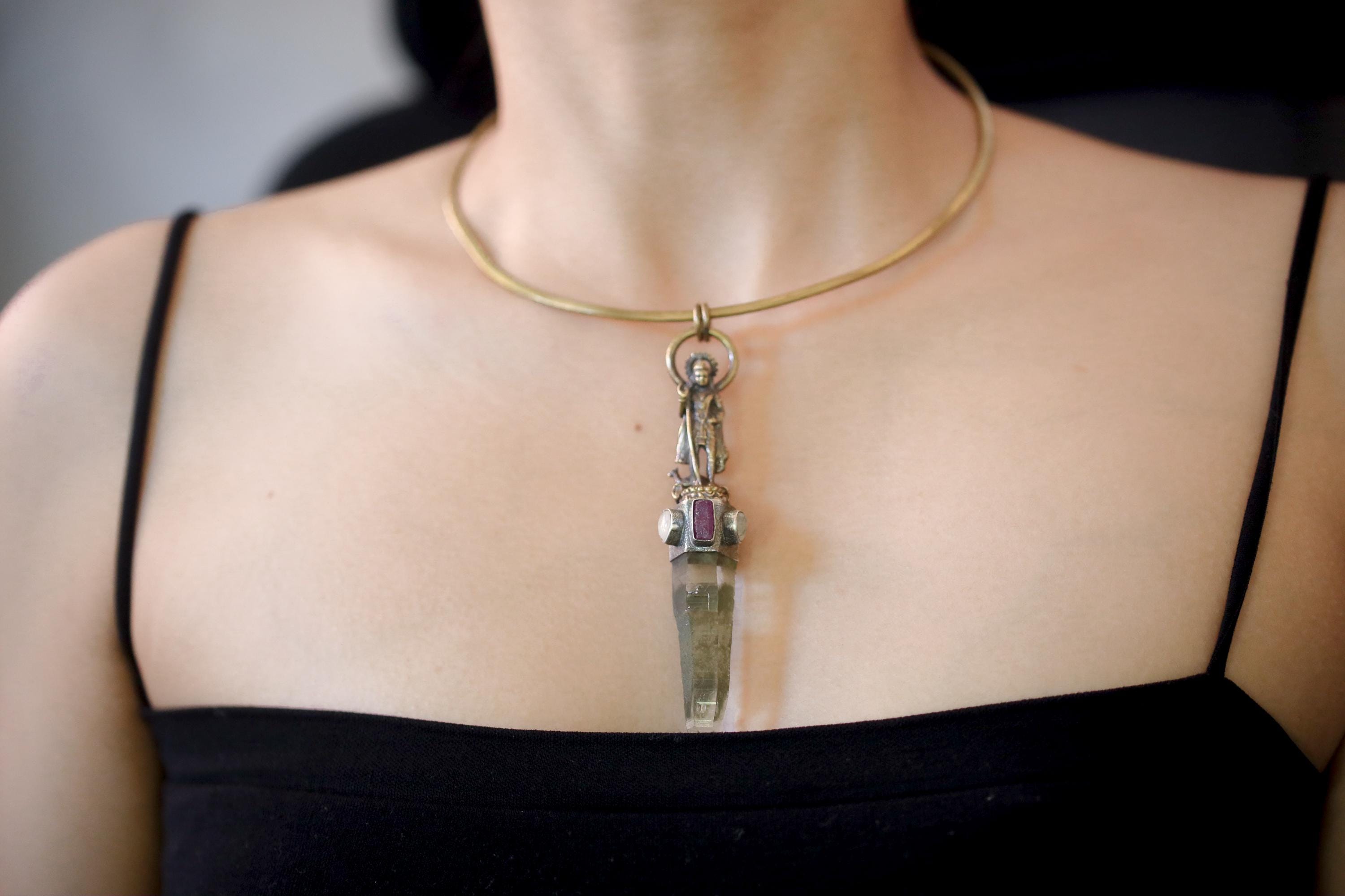 Pendant on model upper chest showing centered positioning and fluid movement with wear.