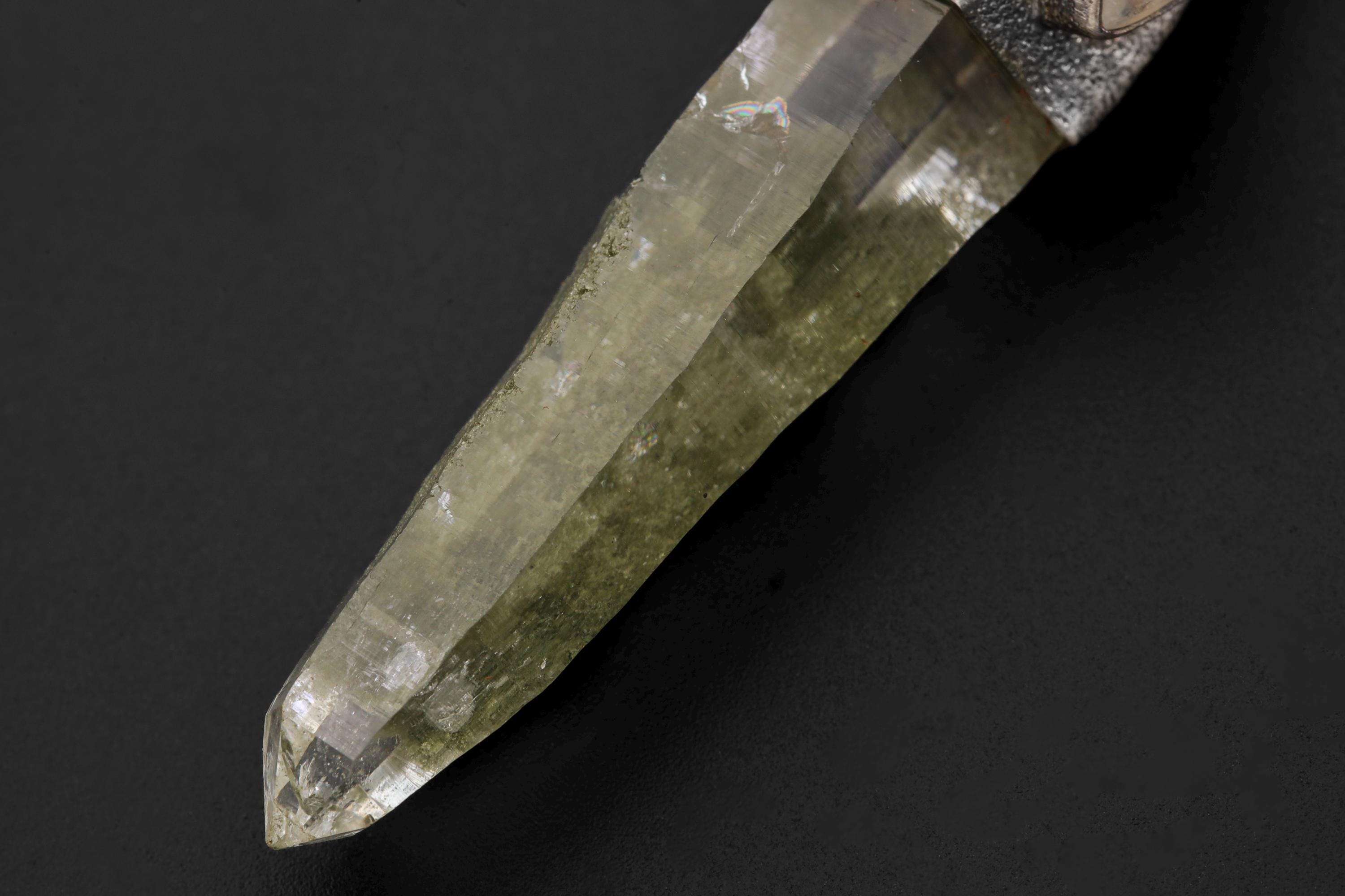 Pendant viewed from angle emphasizing Saraswati figure detailing and fine metal texture.