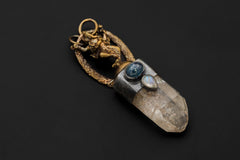 Ganesha Quartz Talisman pendant on black background showing cast brass Ganesha figure above a clear quartz point with silver bezel and pyrite inclusion.