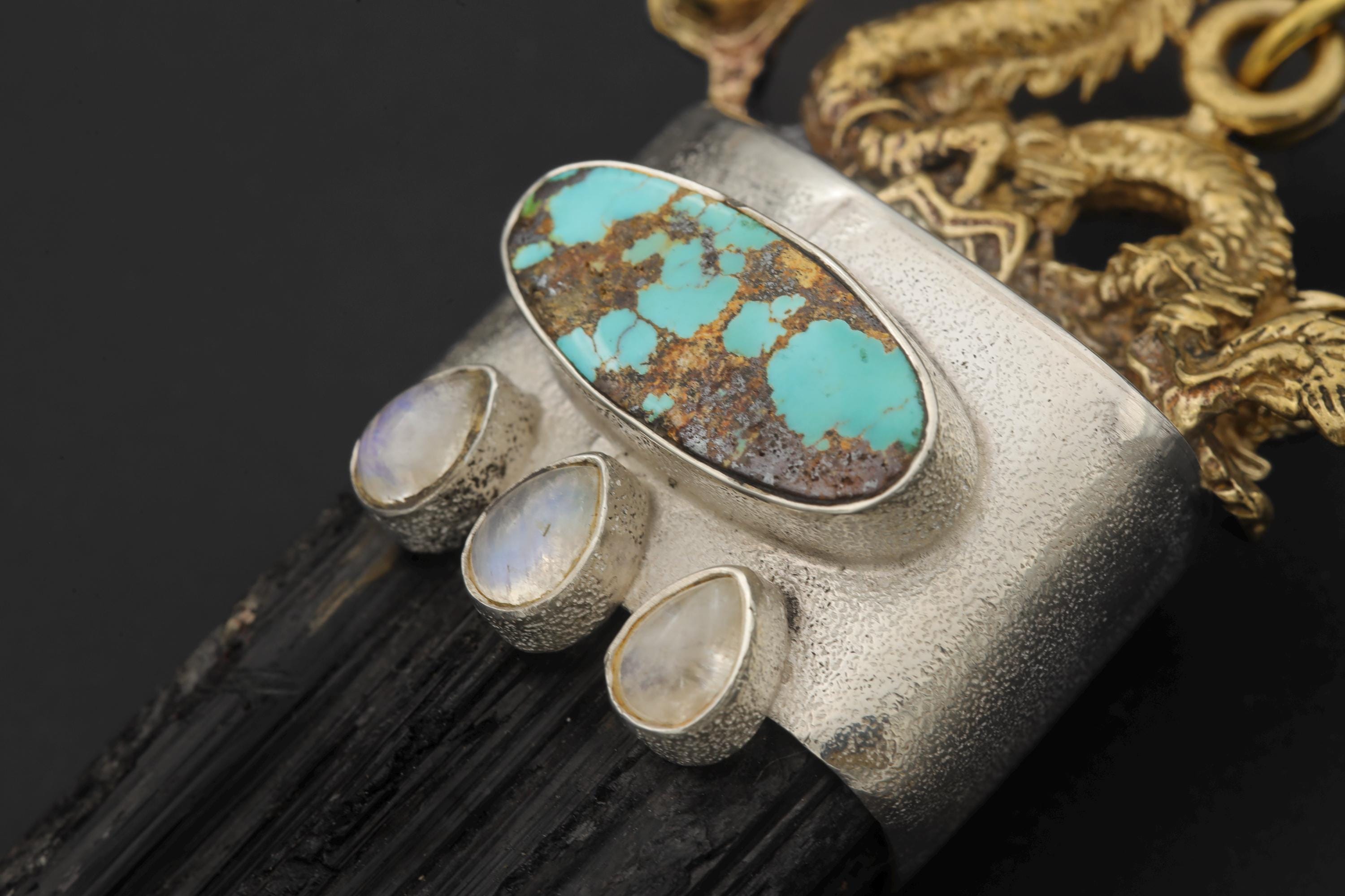 Macro close-up of Sleeping Beauty Turquoise ovals and luminescent Blue Moonstone cabochons in silver bezels.