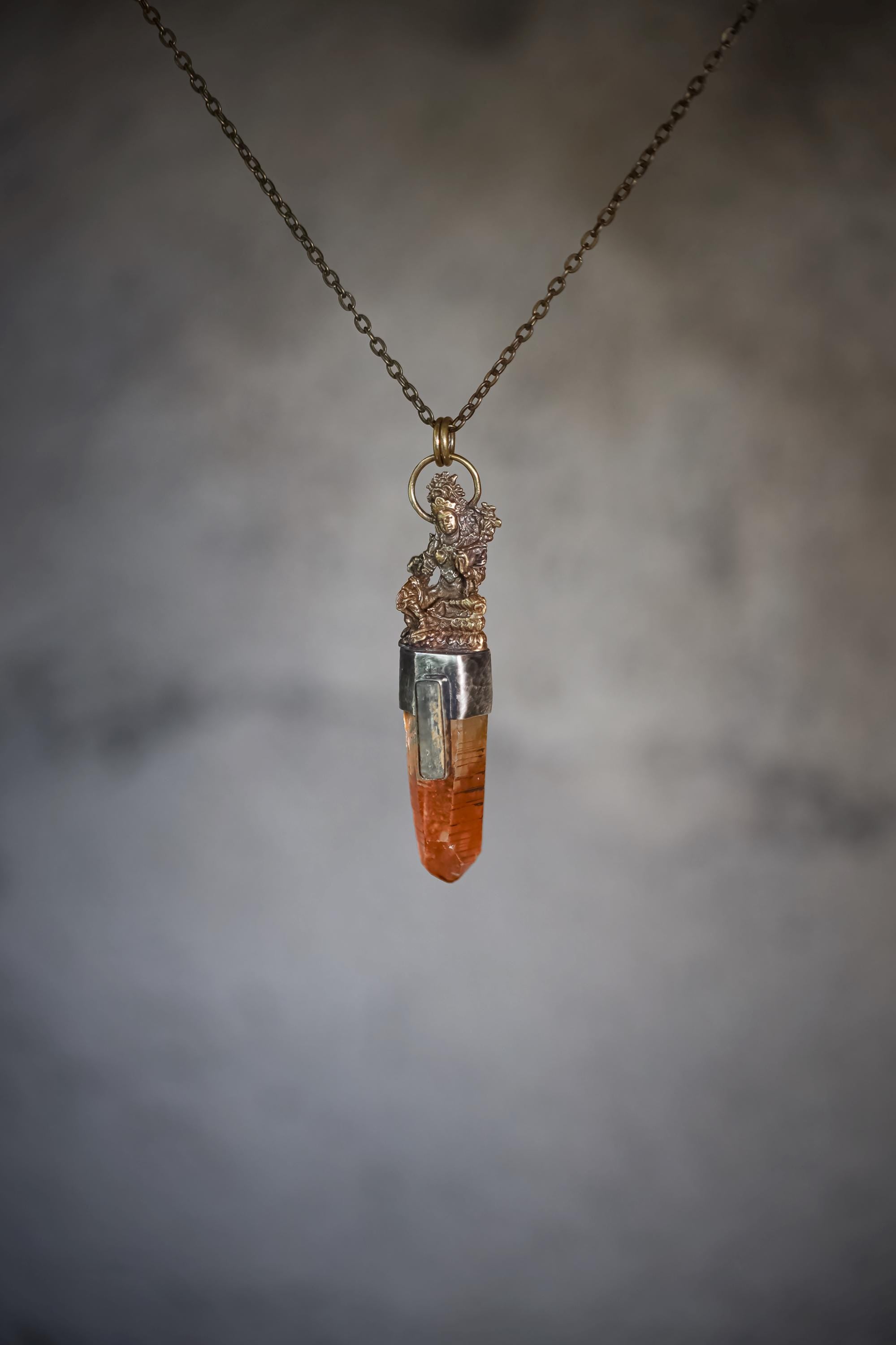 Suspended pendant image with soft gradient background emphasizing light reflection through quartz.