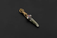 Pendant laid flat on black surface showing full composition from Saraswati figure to quartz termination with visible striations.