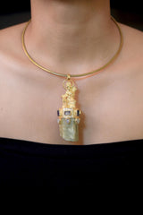Pendant worn on model chest displaying full pendant length and proportion, showing the luminous mix of gold, purple, blue, and green hues under natural light.